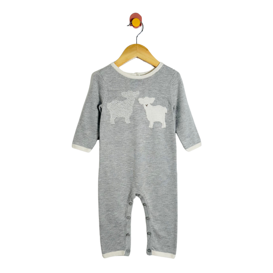 Gray baby onesie with animal prints on a wooden hanger against a white background