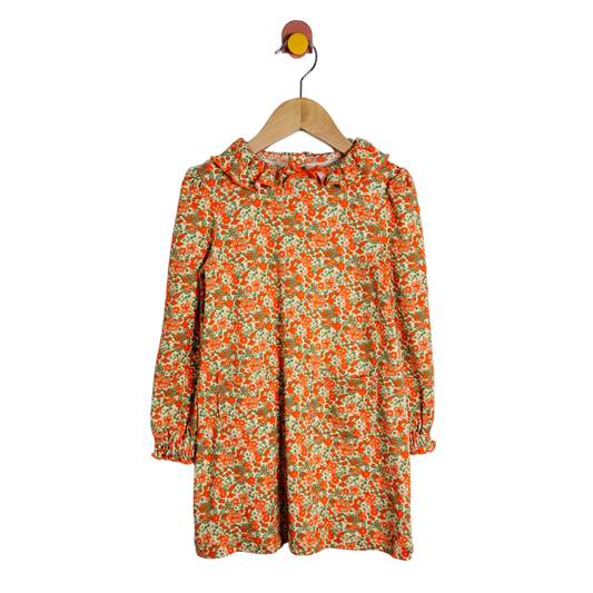 Floral dress on a hanger against a white background