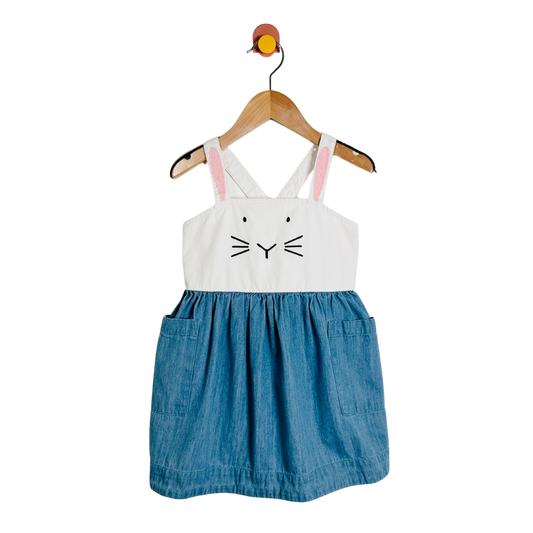 Children's dress with bunny face design on a hanger against a white background