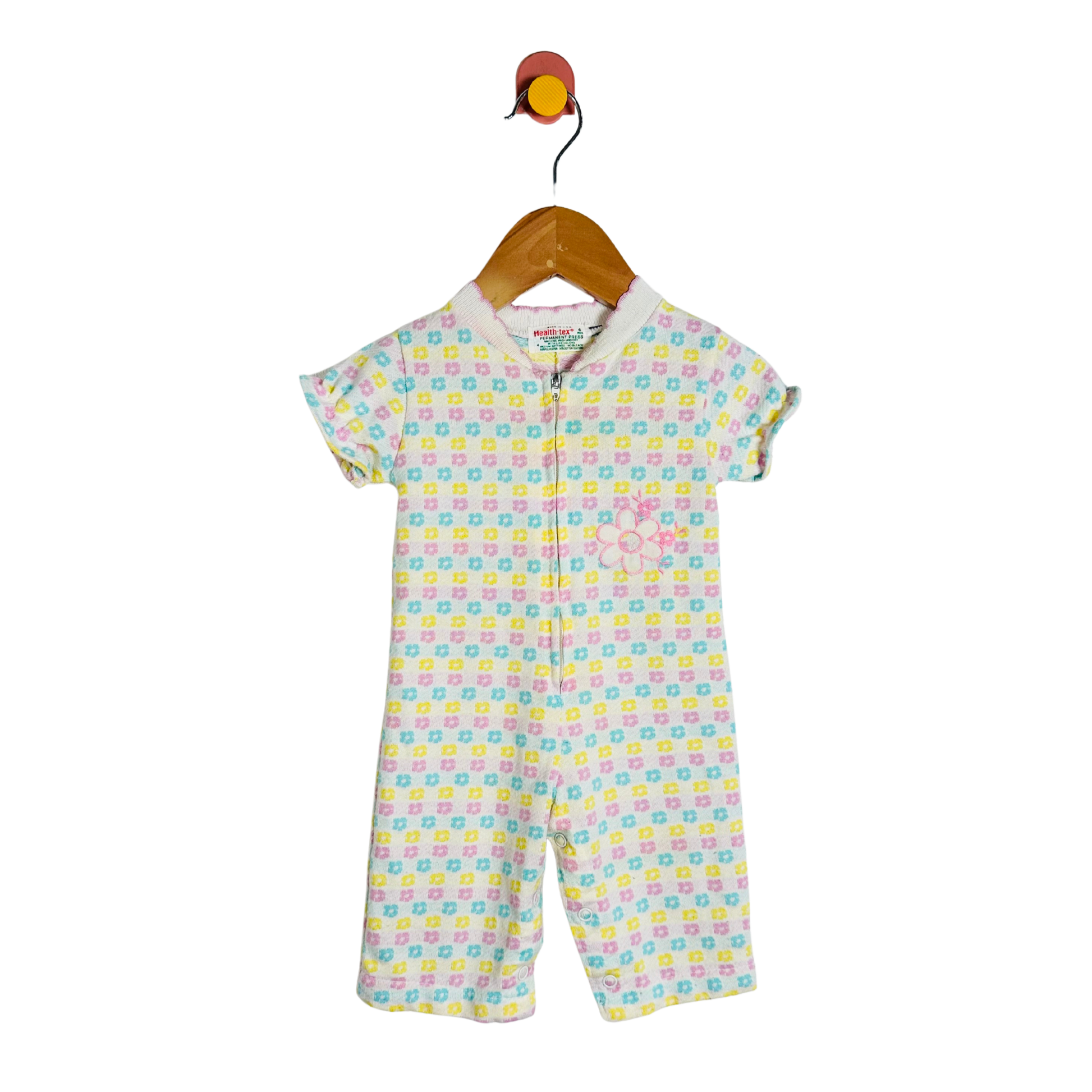 Colorful baby romper with a pattern on a hanger against a white background