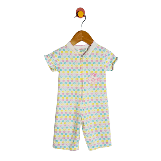Colorful baby romper with a pattern on a hanger against a white background