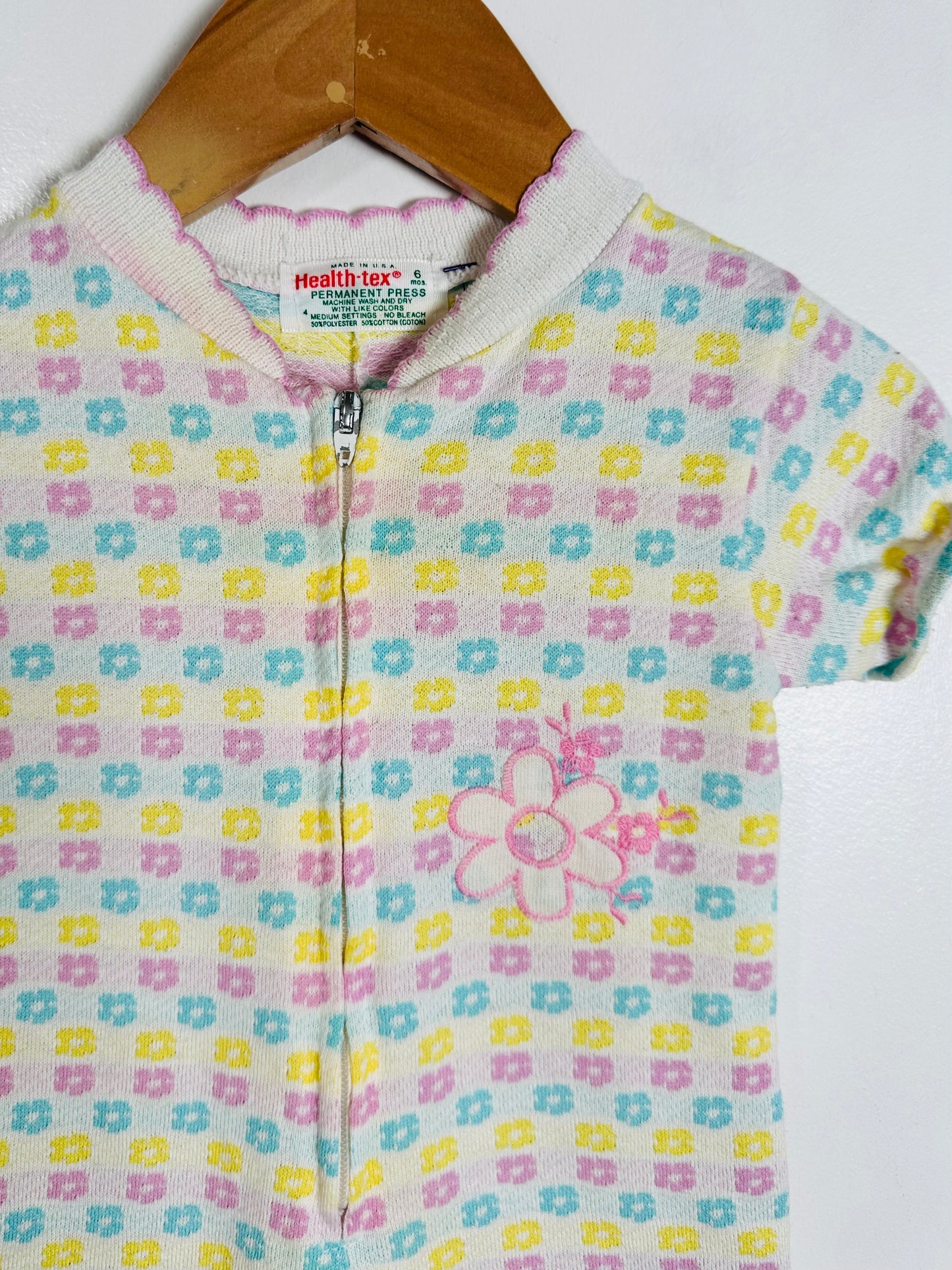 Children's onesie with floral pattern on a hanger