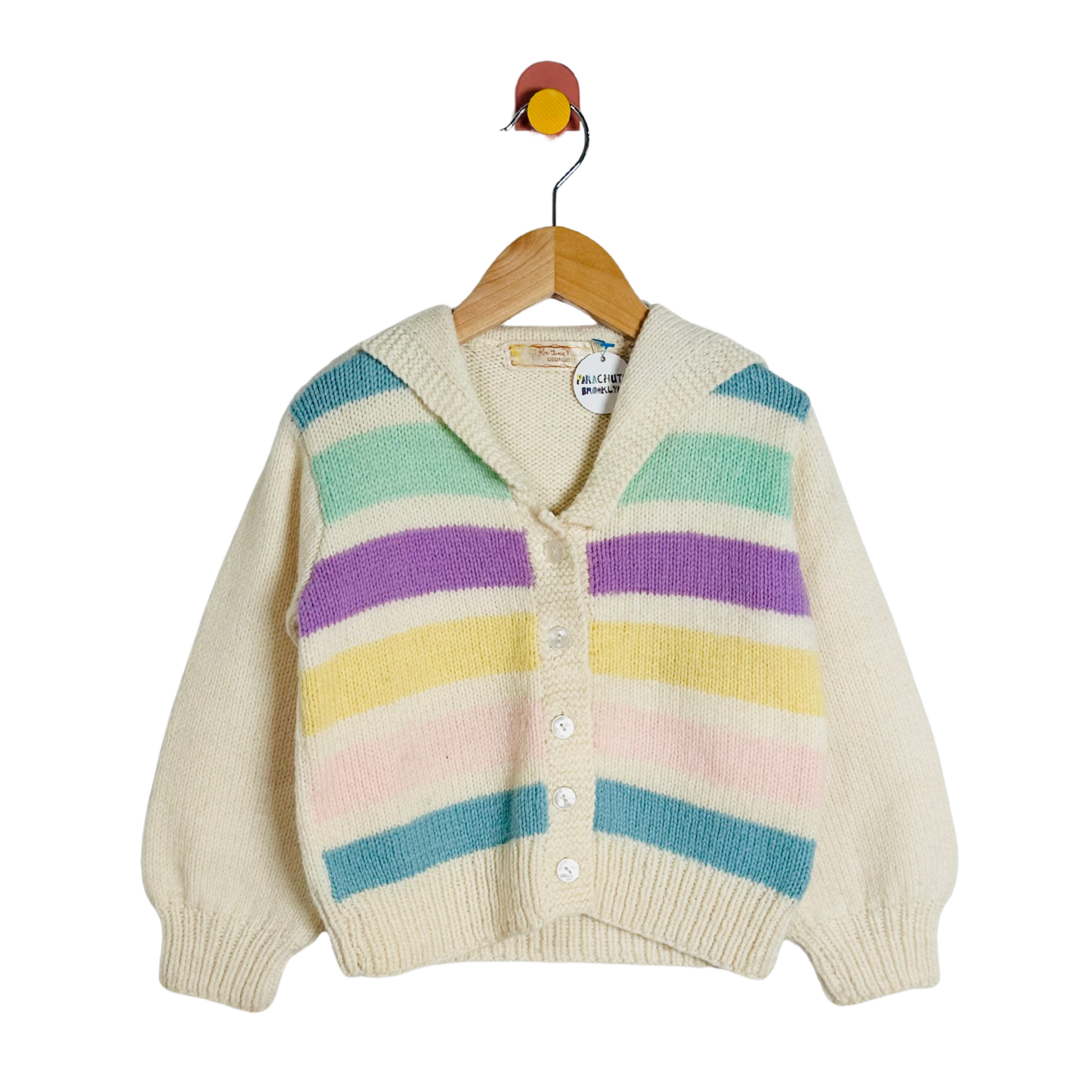 Children's cardigan with colorful stripes on a hanger against a white background