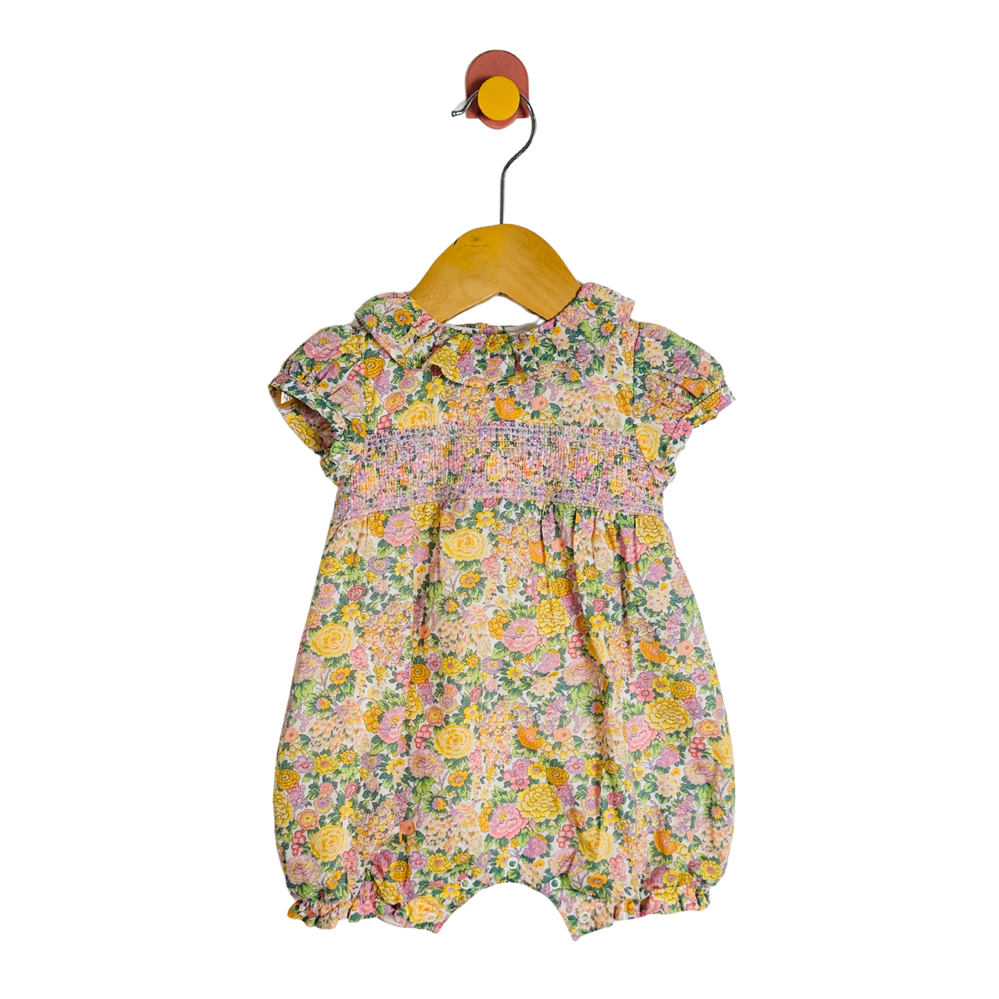 Floral baby romper on a hanger against a white background