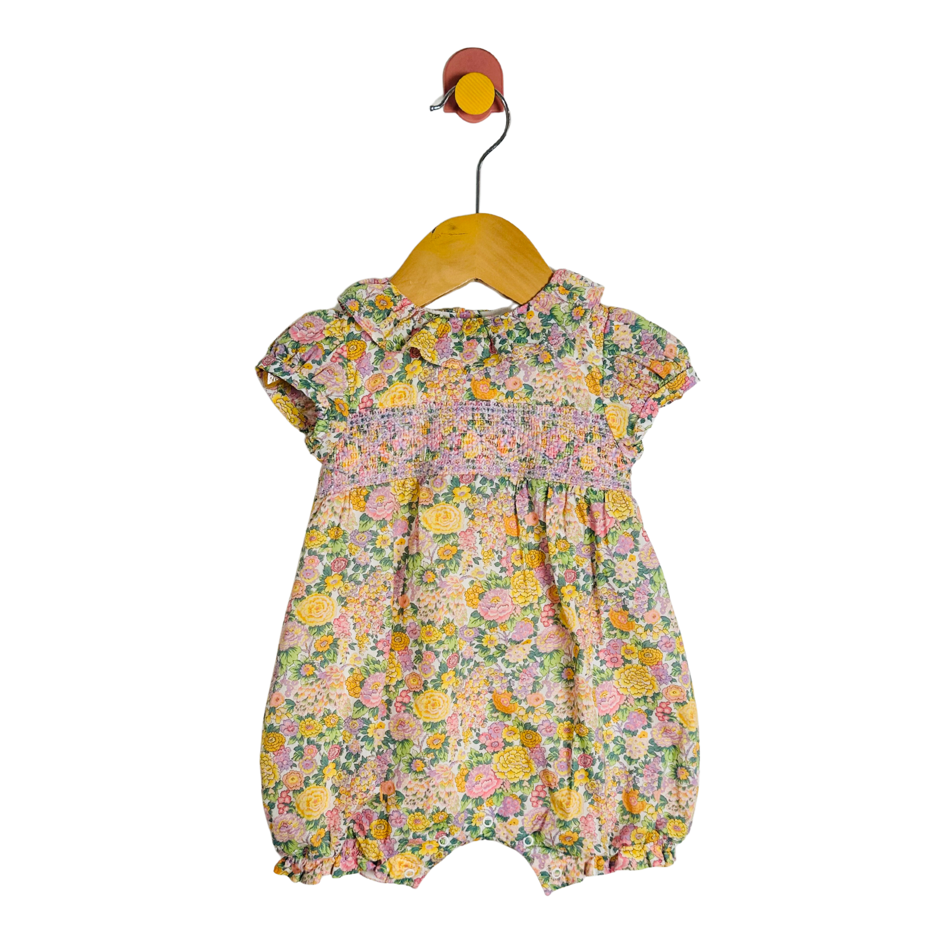 Floral baby romper on a hanger against a white background
