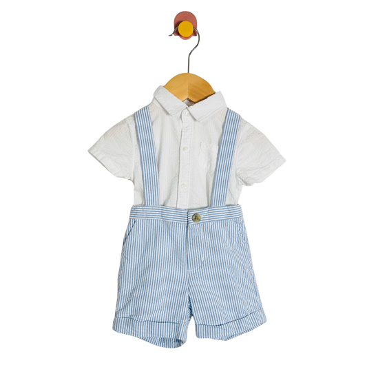 Children's outfit with white shirt, blue striped suspenders, and shorts on a hanger against a white background.