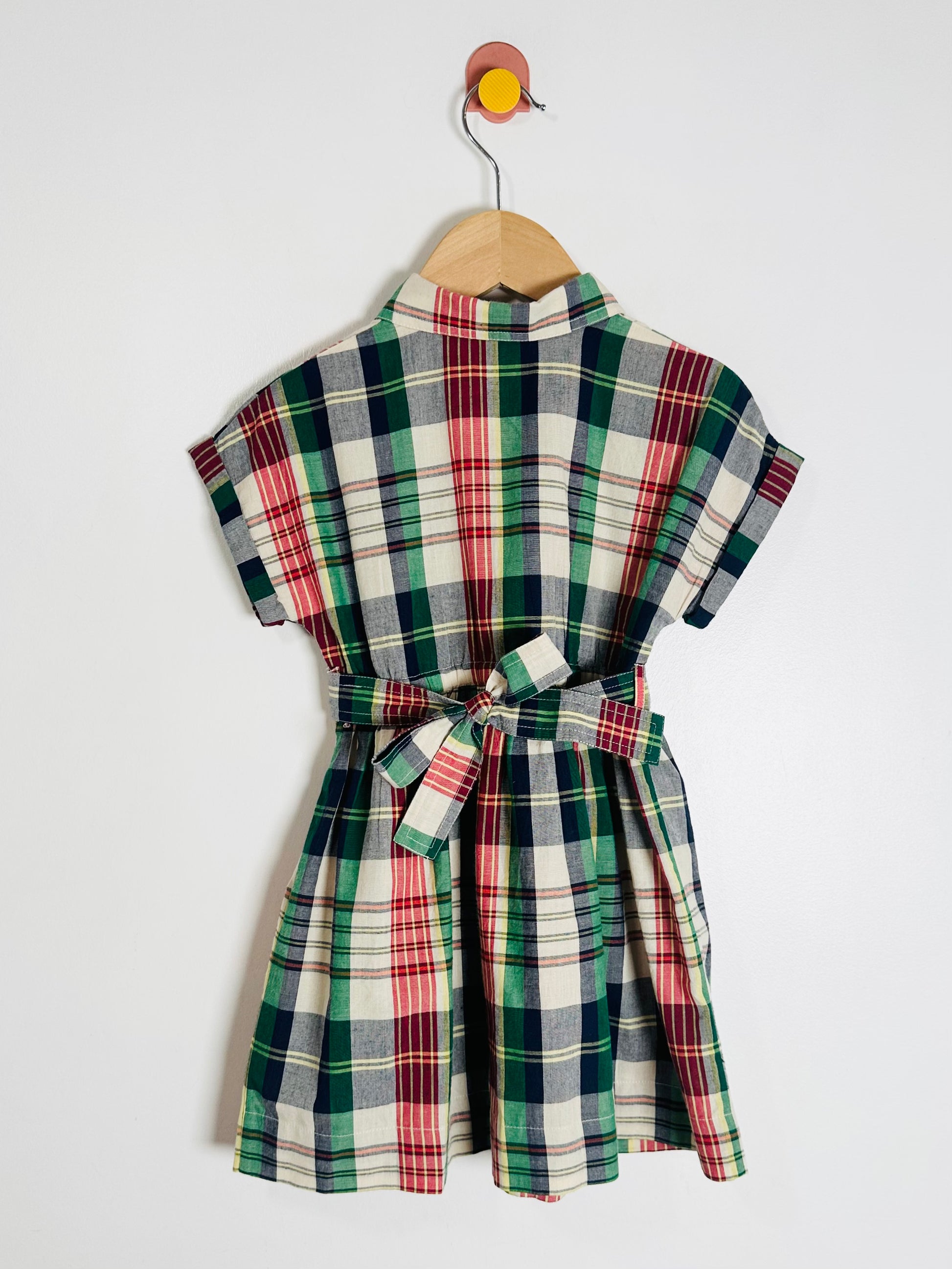 Plaid dress on a hanger against a white background
