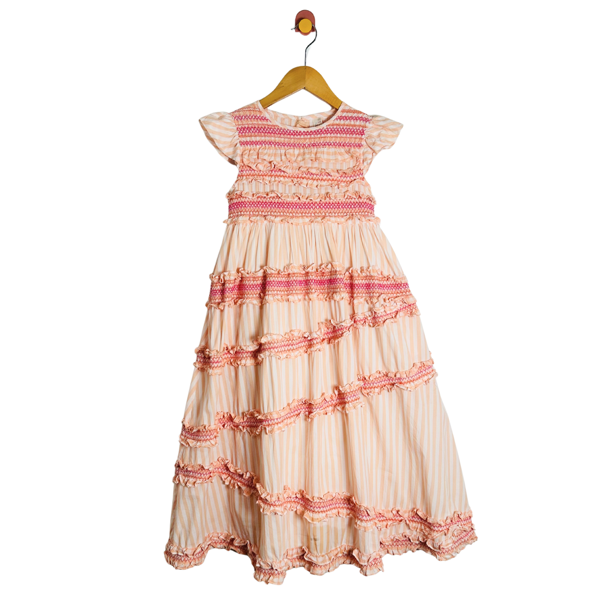 Beige and pink dress on a hanger against a white background