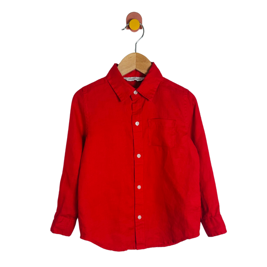 Red shirt on a wooden hanger against a white background