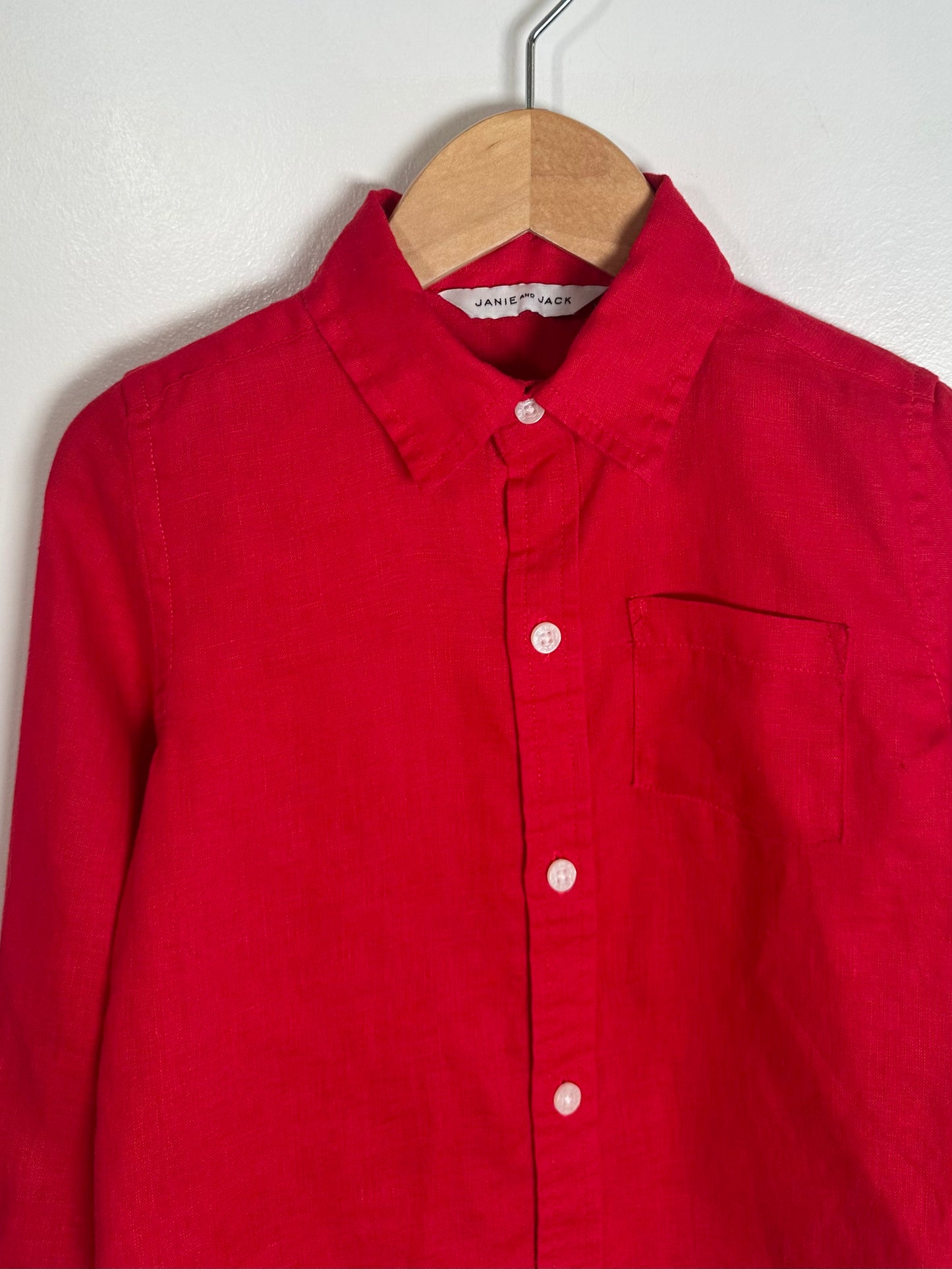 Red shirt on a hanger against a white background
