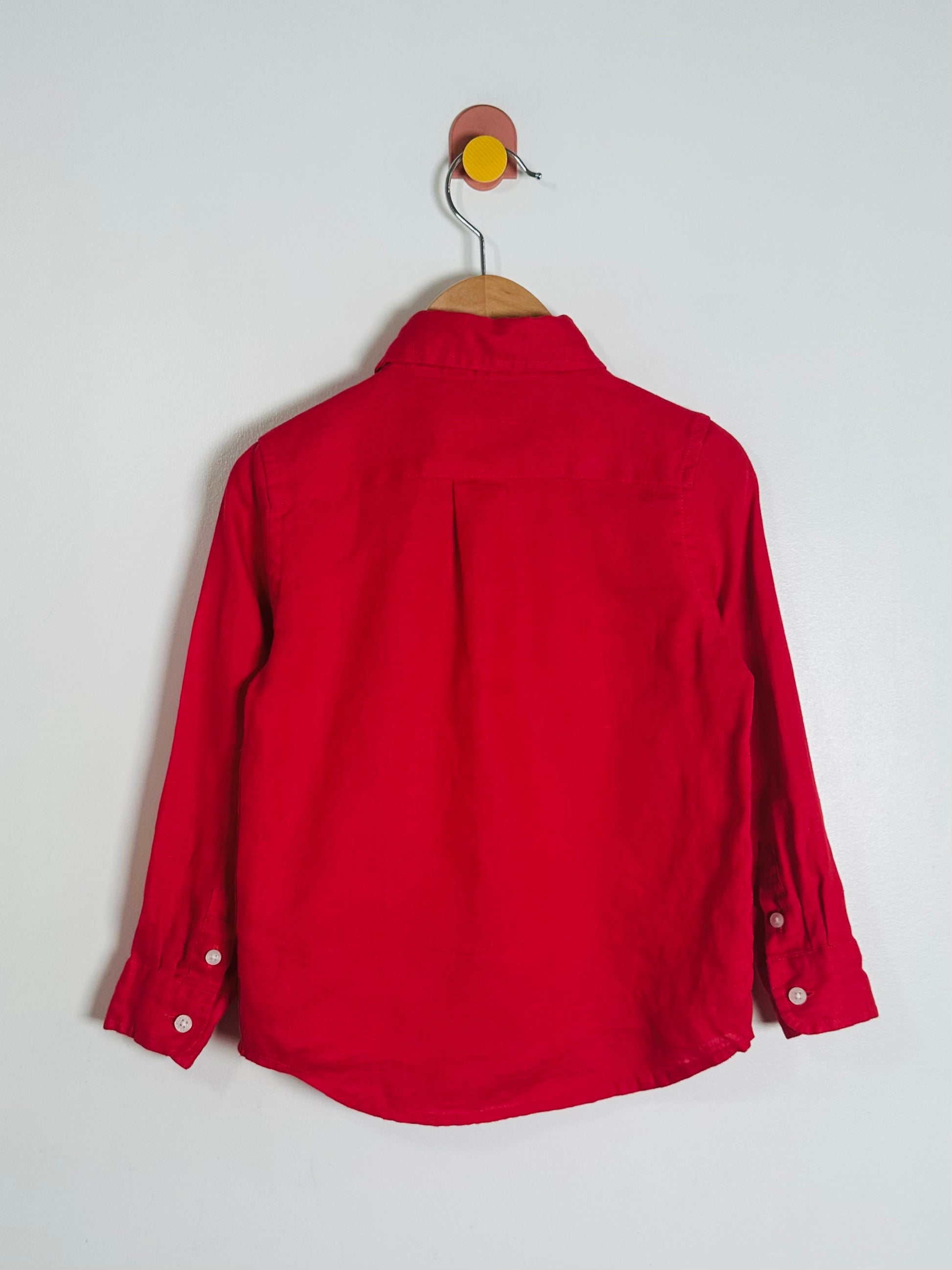 Red shirt on a hanger against a white background