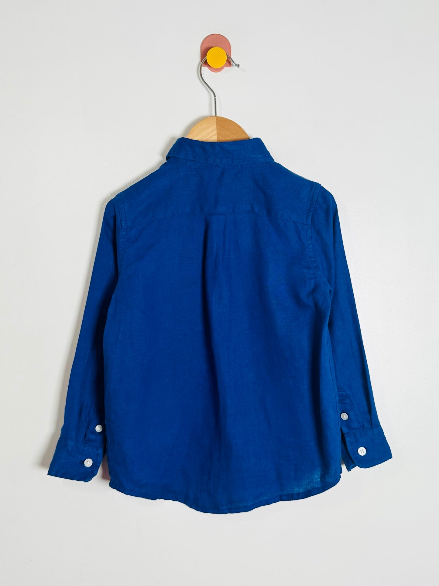 Blue shirt on a hanger against a white background