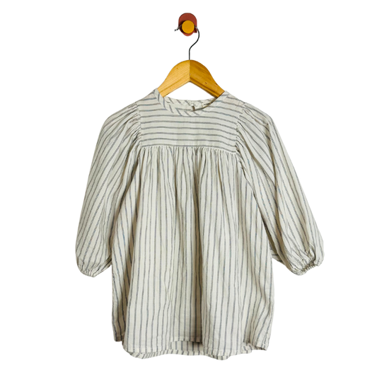 Striped blouse on a wooden hanger against a white background