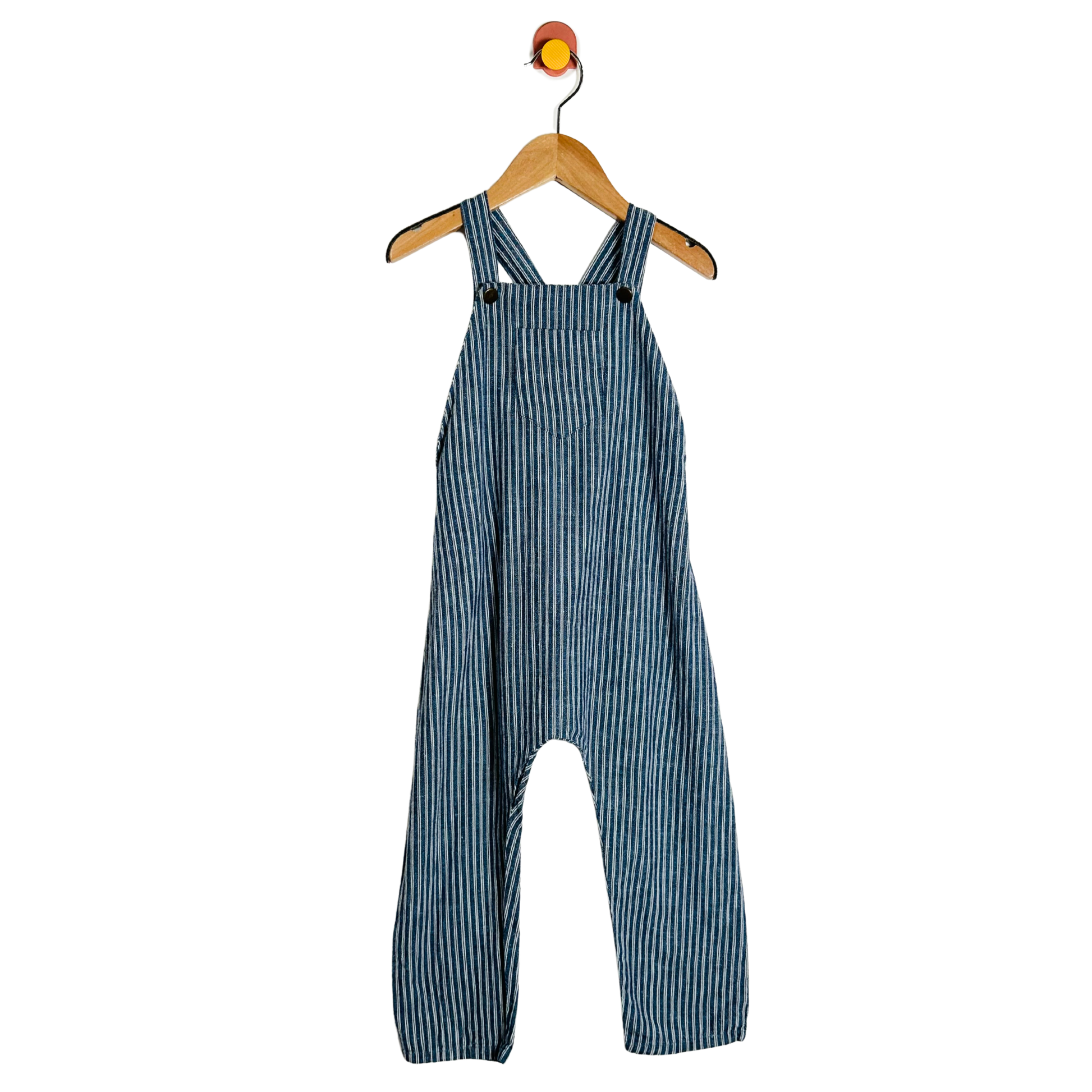 Blue striped overalls hanging on a wooden hanger against a white background