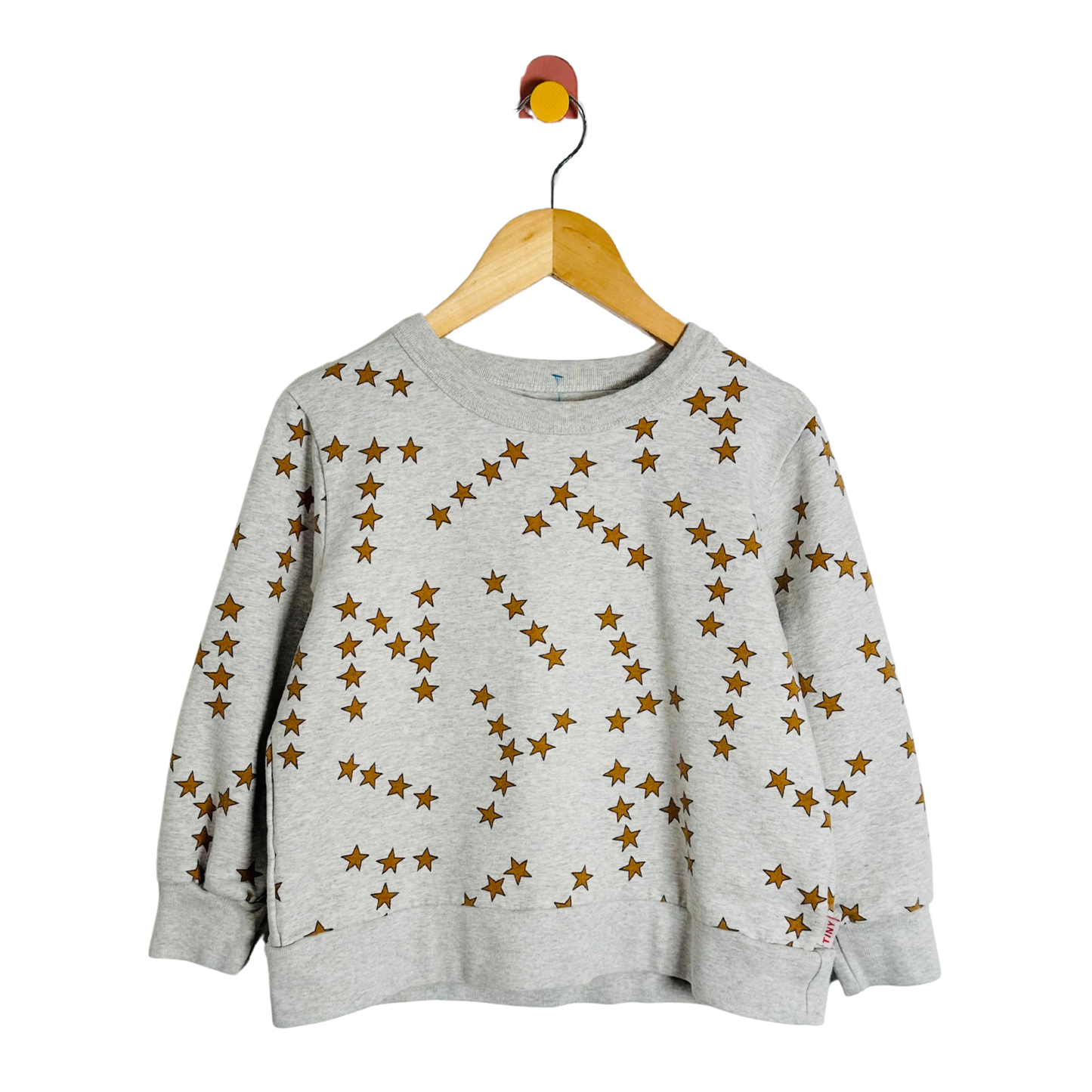 Gray sweatshirt with star pattern on a wooden hanger against a white background