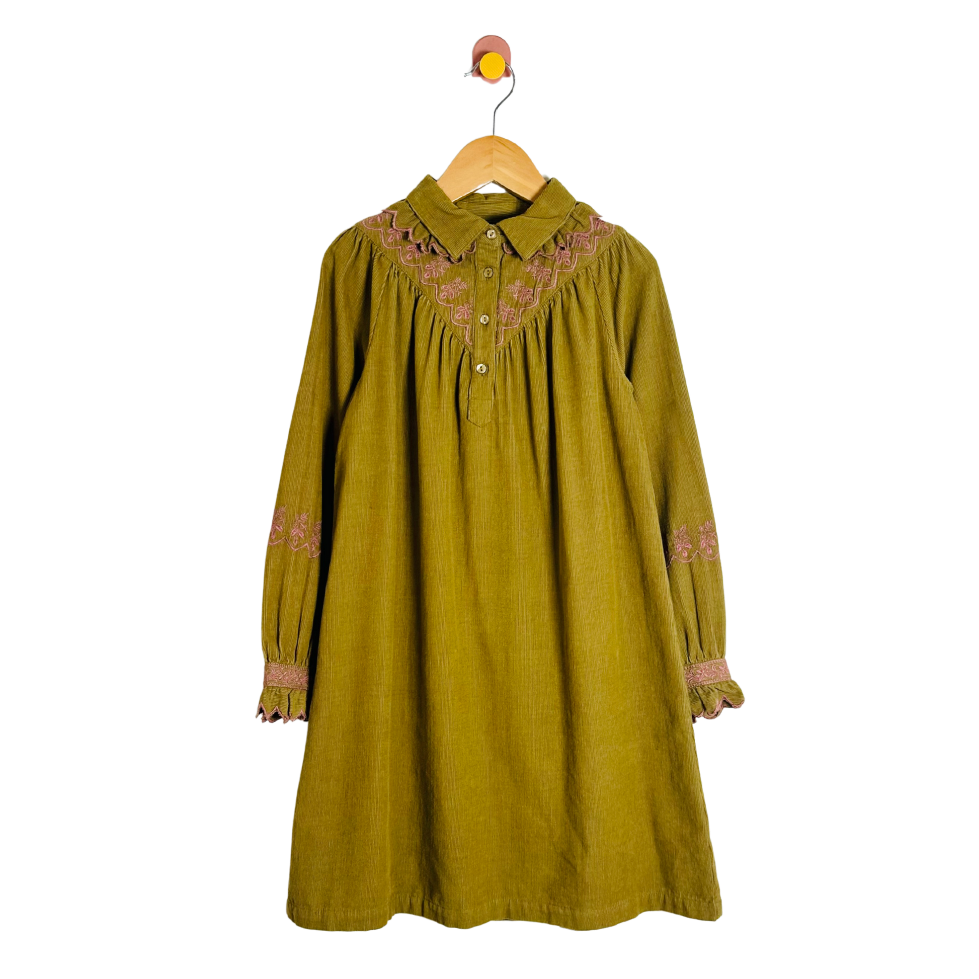Green dress with floral embroidery on a hanger against a white background