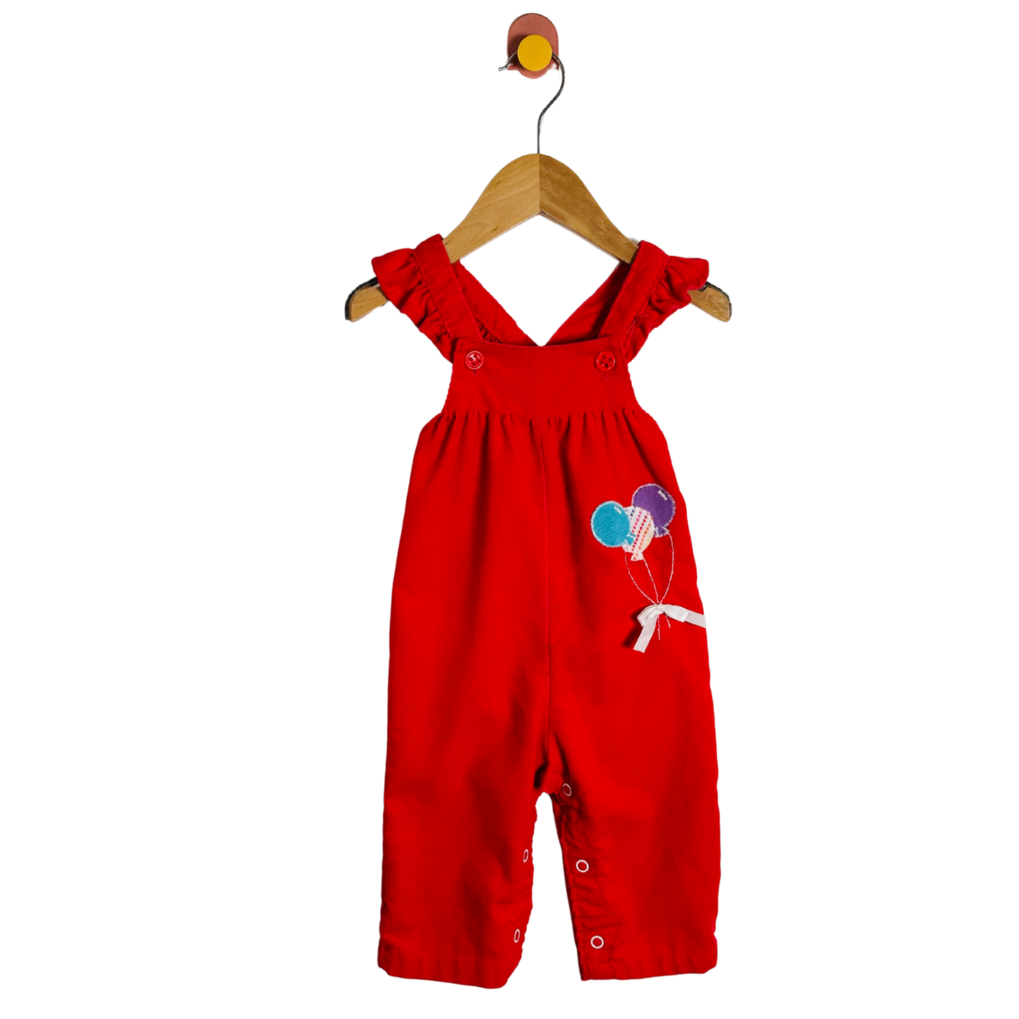 Red children's overalls with balloon design on a white background