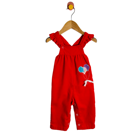 Red children's overalls with balloon design on a white background
