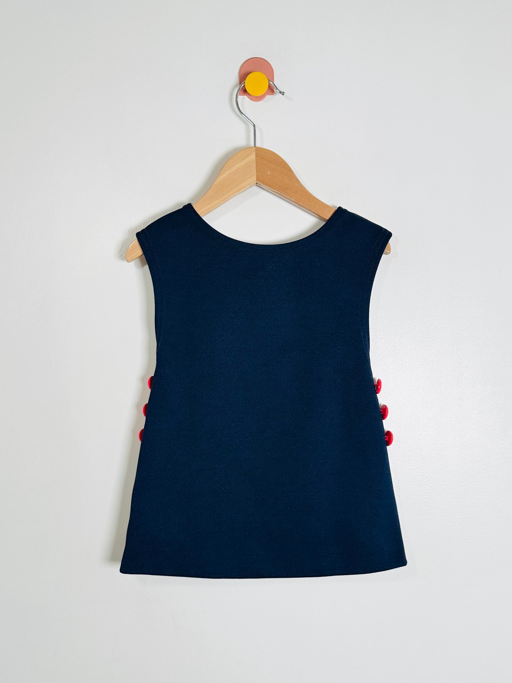 Navy blue sleeveless dress with red accents on a white background