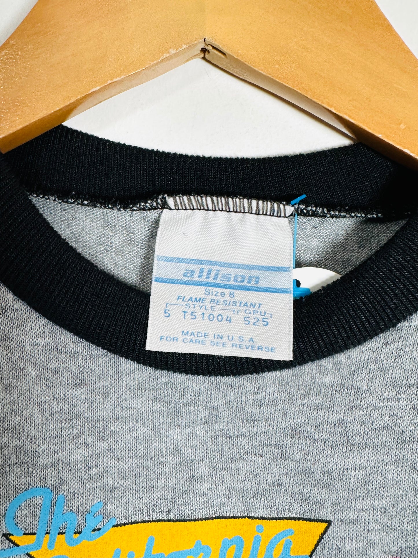 Gray sweatshirt with black trim and a visible label on a white background