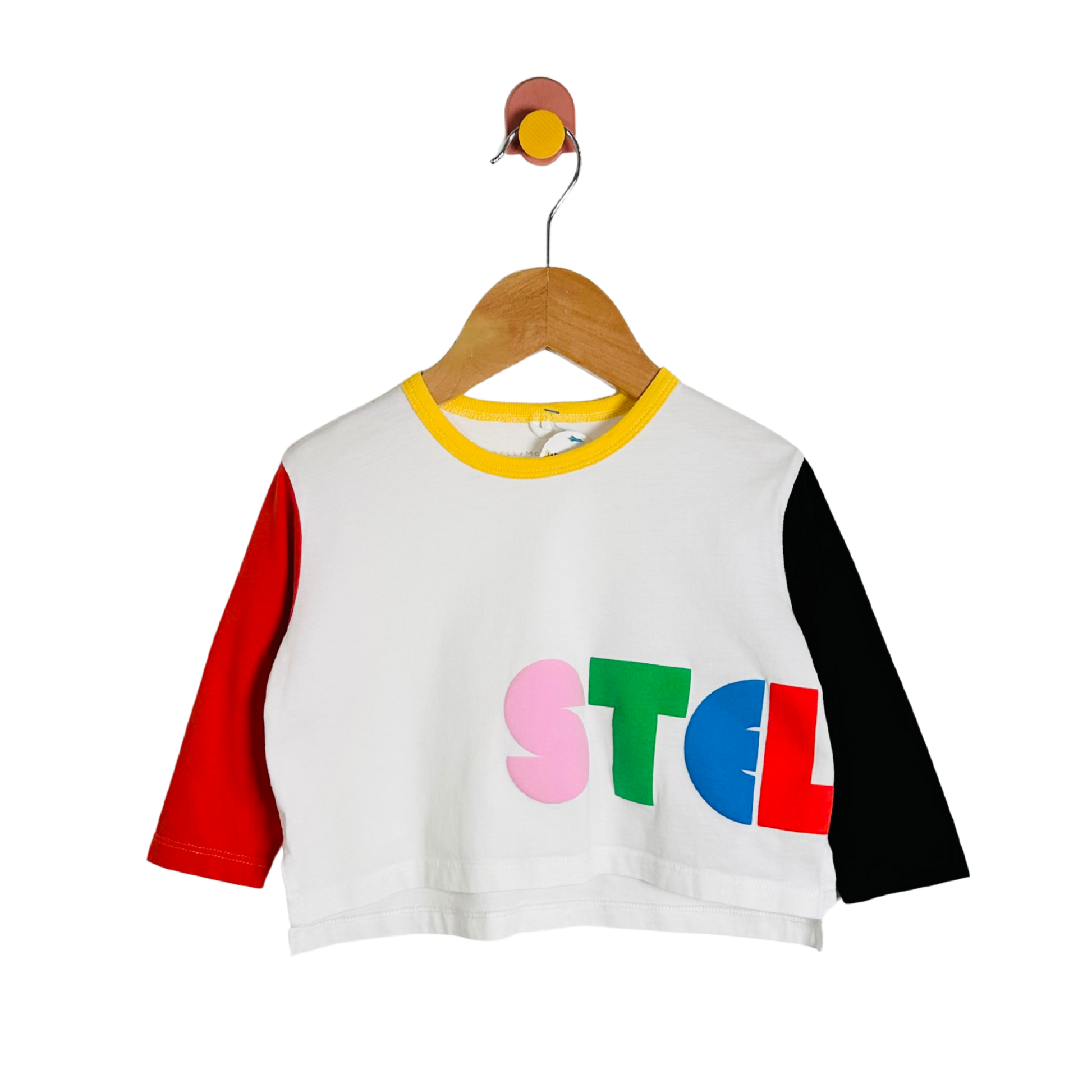 White crop top with colorful letters on a wooden hanger against a white background