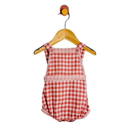 Red and white checkered romper on a wooden hanger against a white background