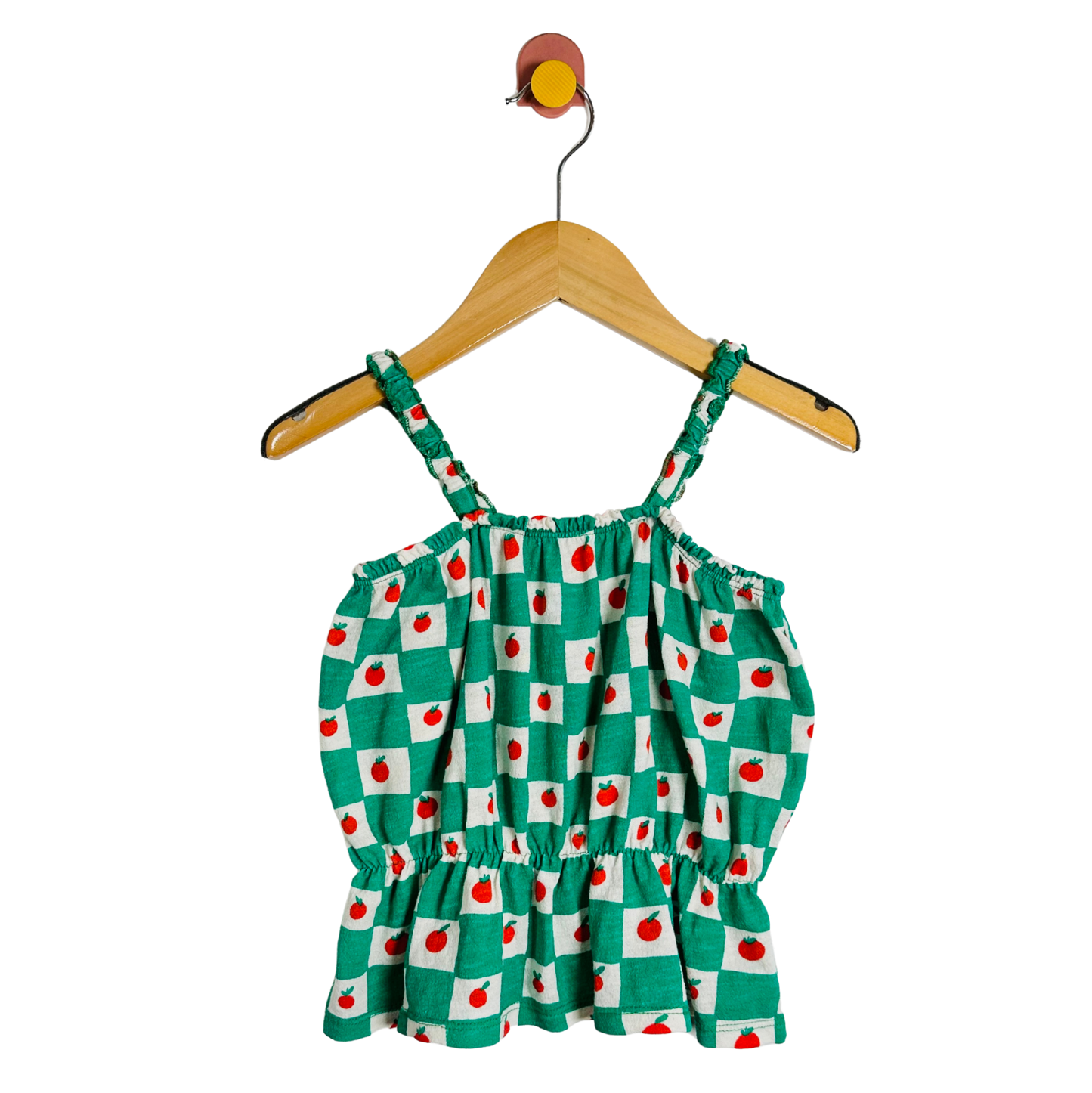 Green checkered dress with red apples on a hanger against a white background