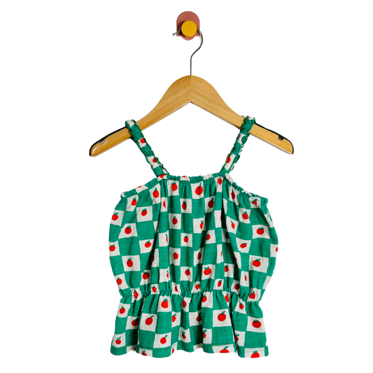 Green checkered dress with red apples on a hanger against a white background
