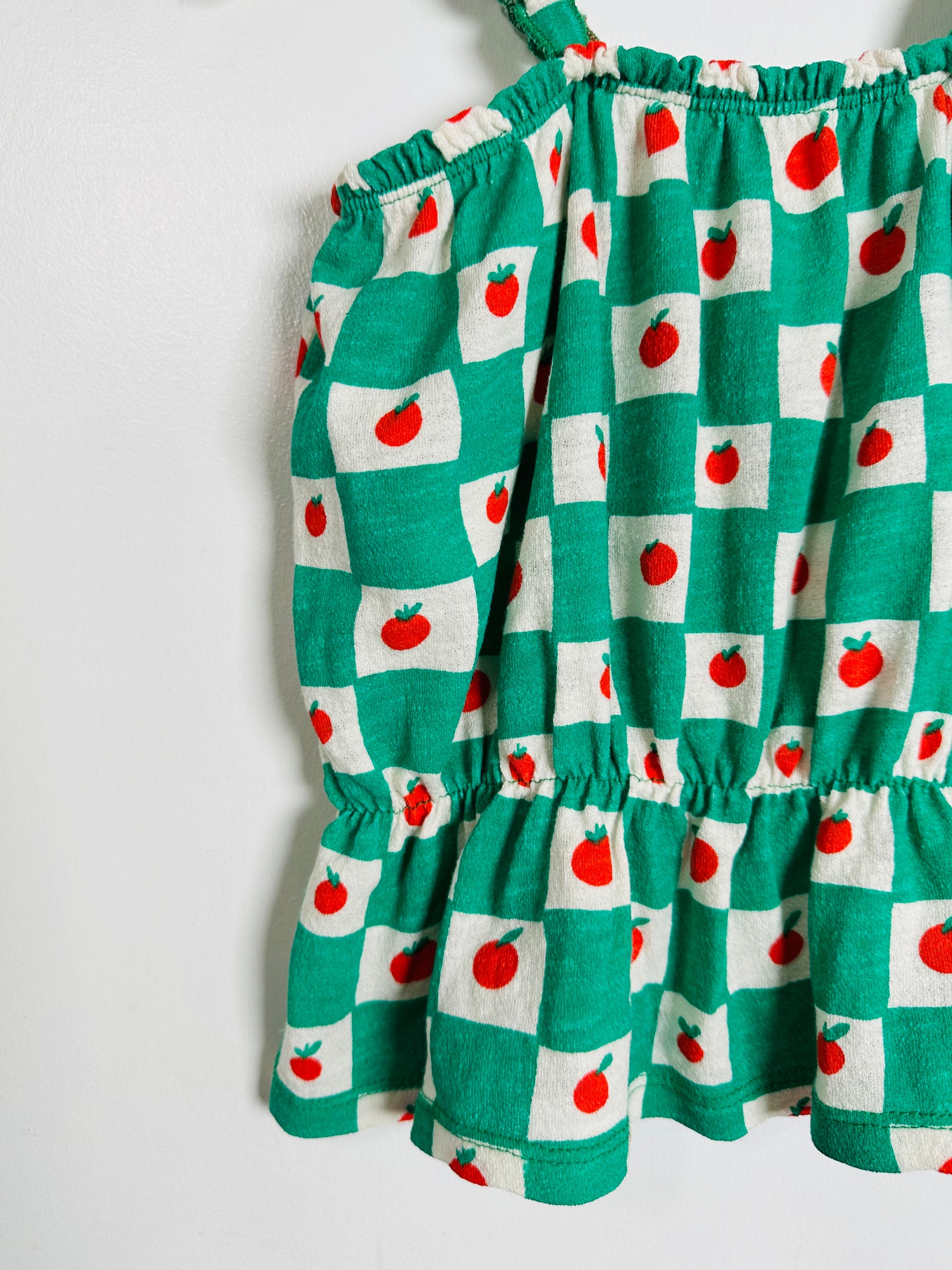 Green checkered dress with red apple pattern on a white background