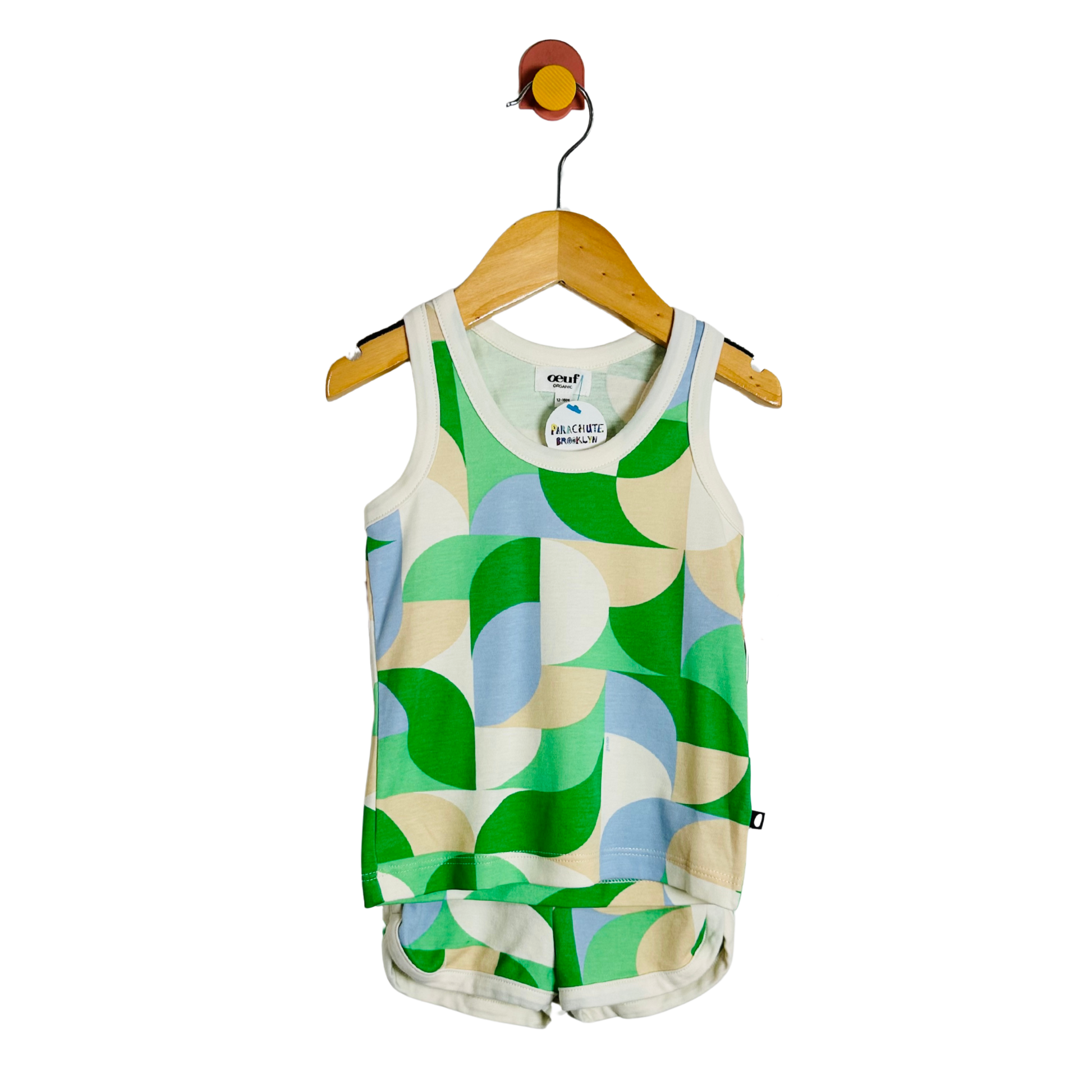 Children's tank top with geometric pattern on a wooden hanger against a white background