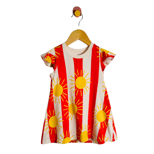Red and white dress with yellow sun patterns on a hanger against a white background