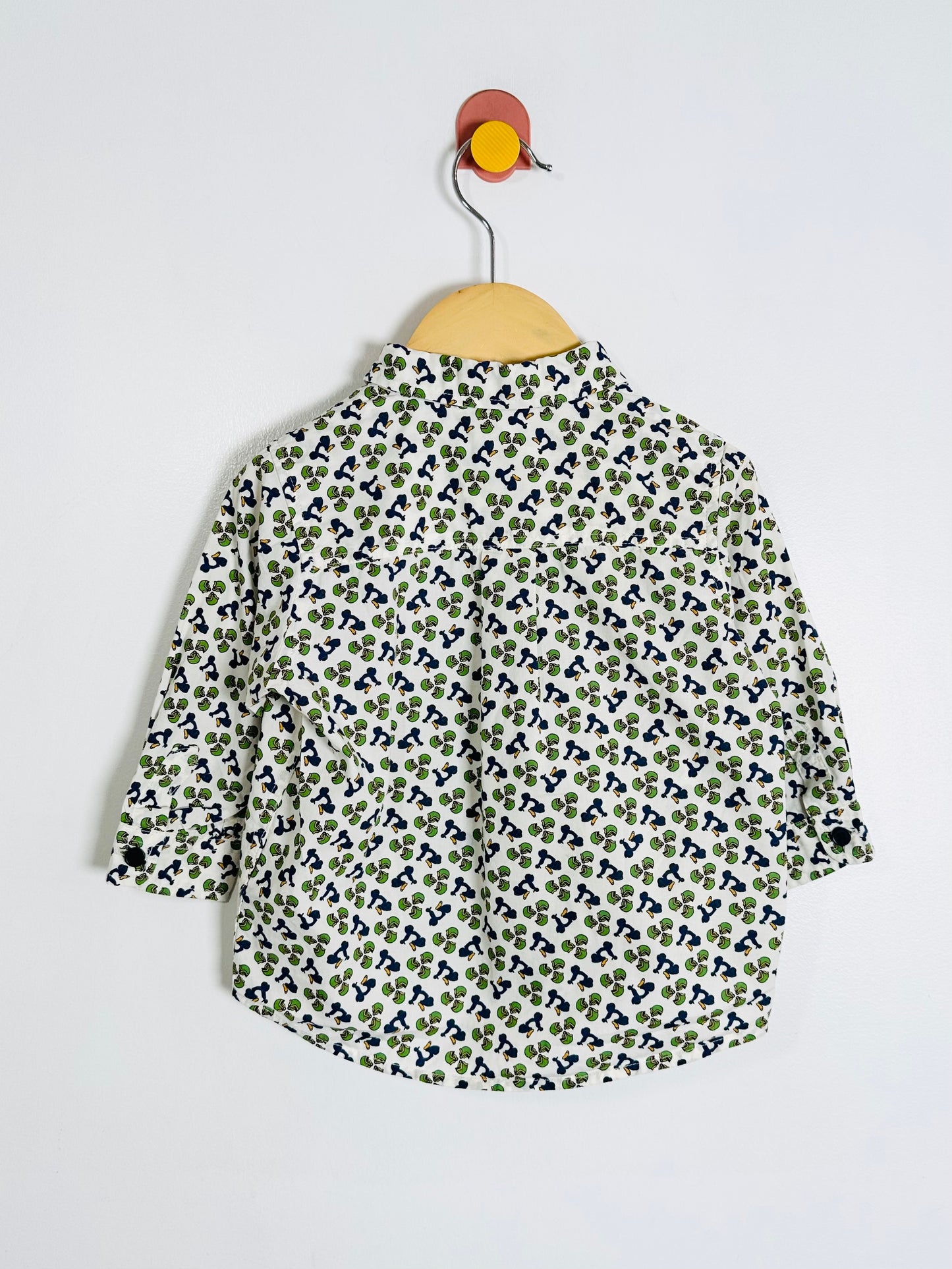 Floral patterned shirt on a hanger against a white background