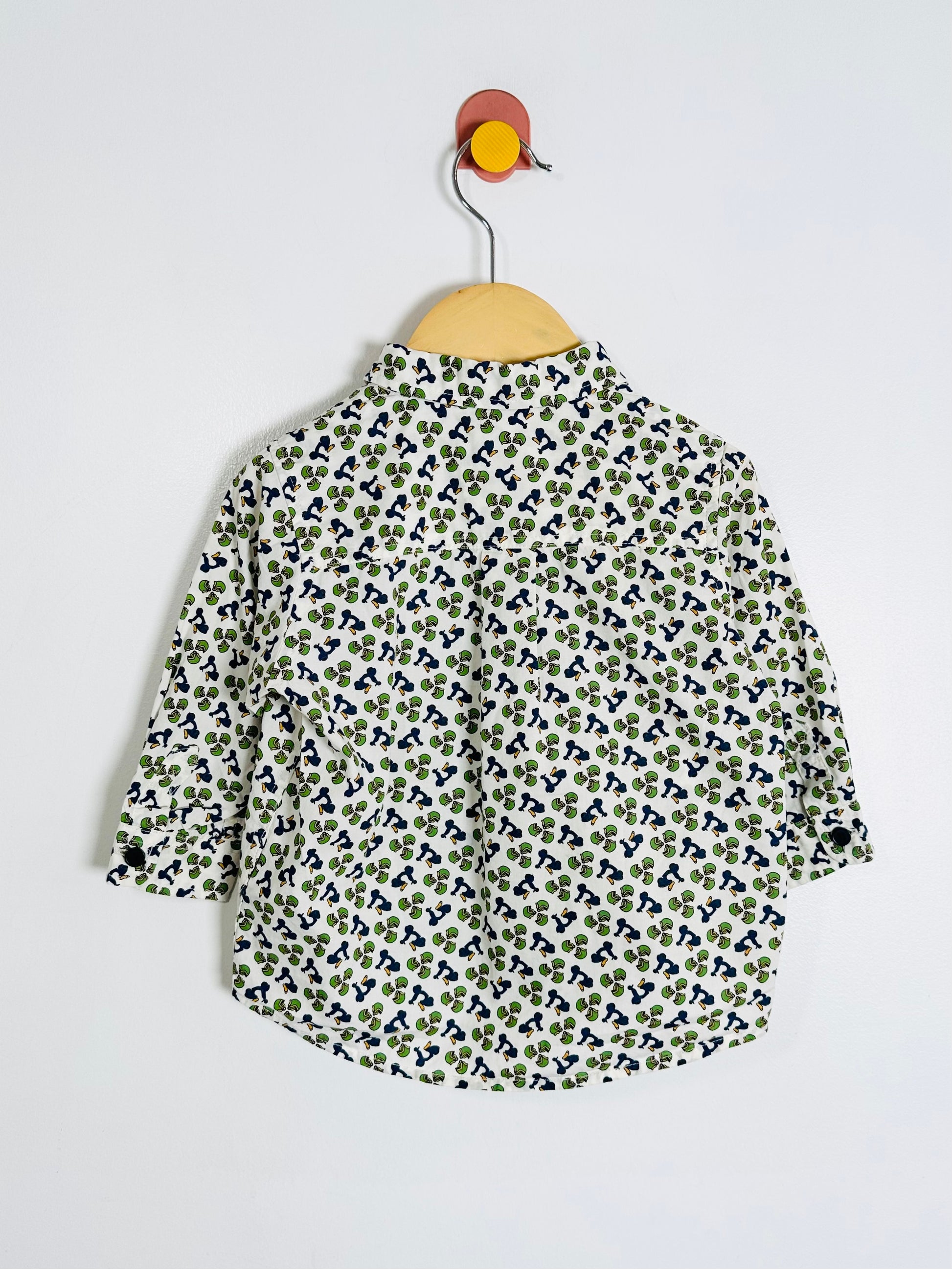 Floral patterned shirt on a hanger against a white background