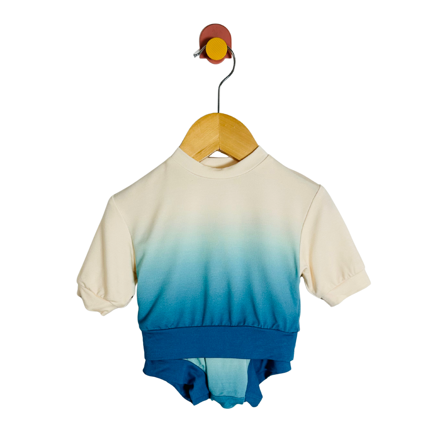 Gradient shirt with beige to blue color change on a hanger against a white background