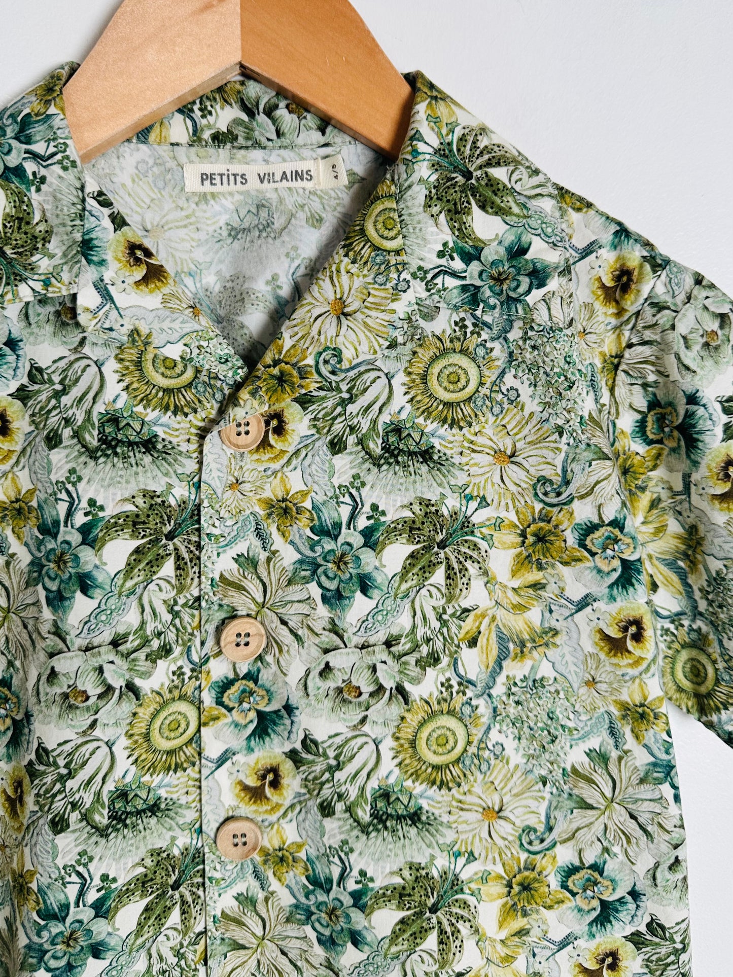 Floral patterned shirt on a hanger with 'Petits Vilains' label.