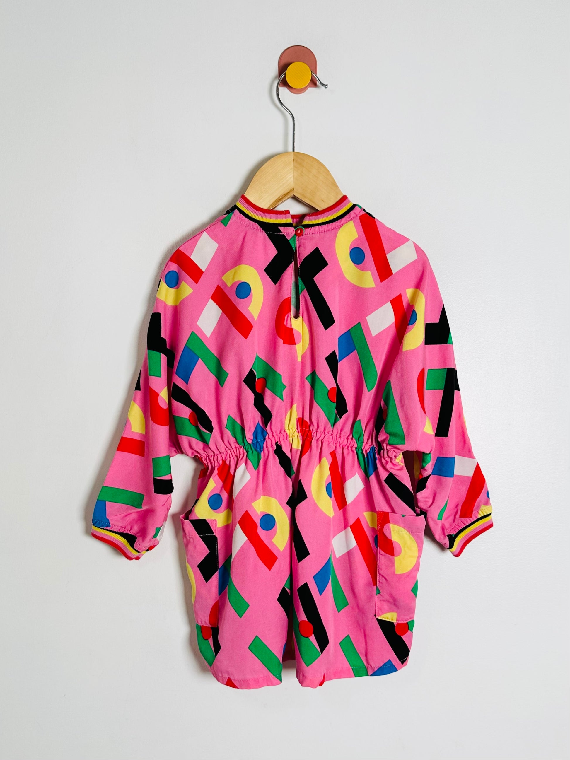 Colorful children's outfit on a hanger against a white background