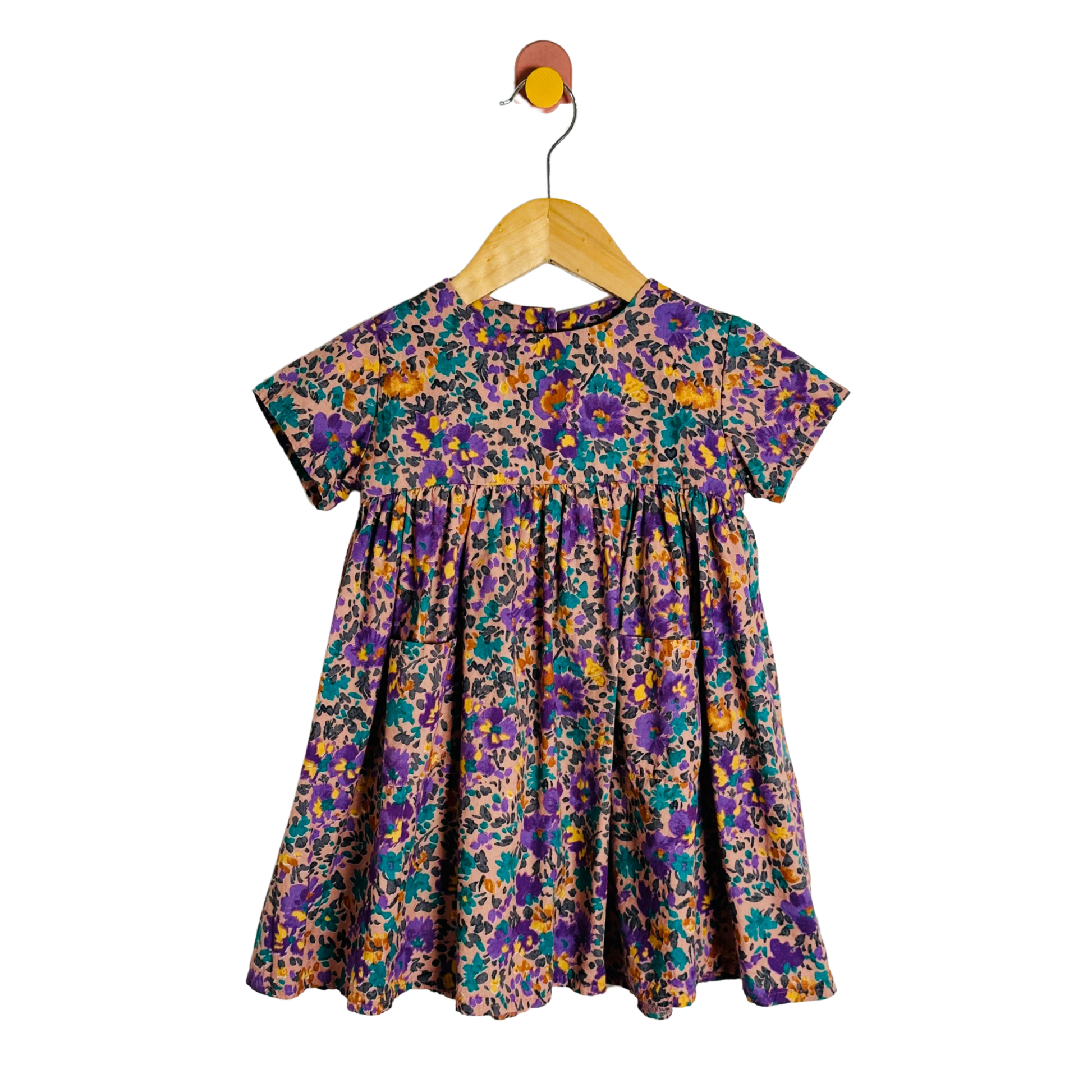 Floral dress on a wooden hanger against a white background
