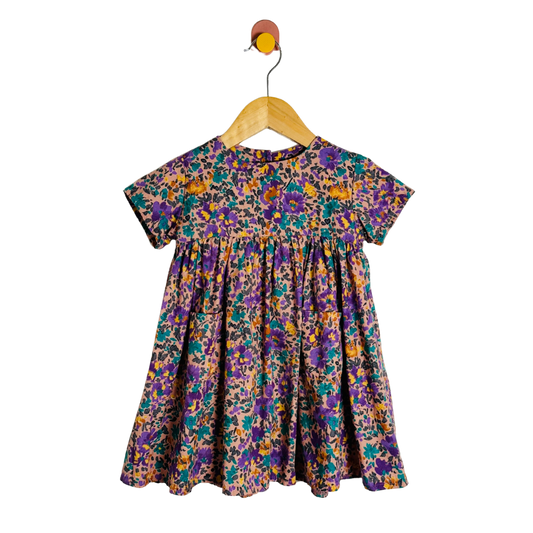 Floral dress on a wooden hanger against a white background