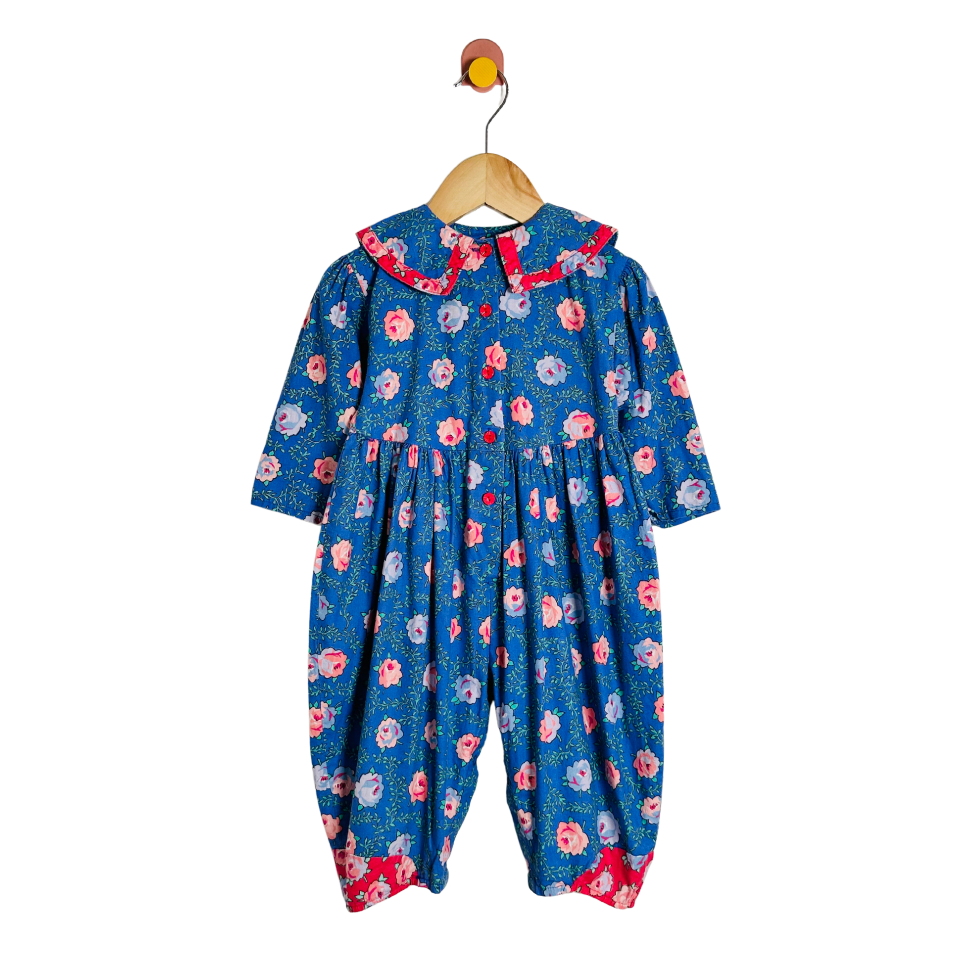 Floral-patterned baby romper on a hanger against a white background