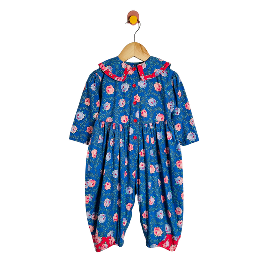 Floral-patterned baby romper on a hanger against a white background