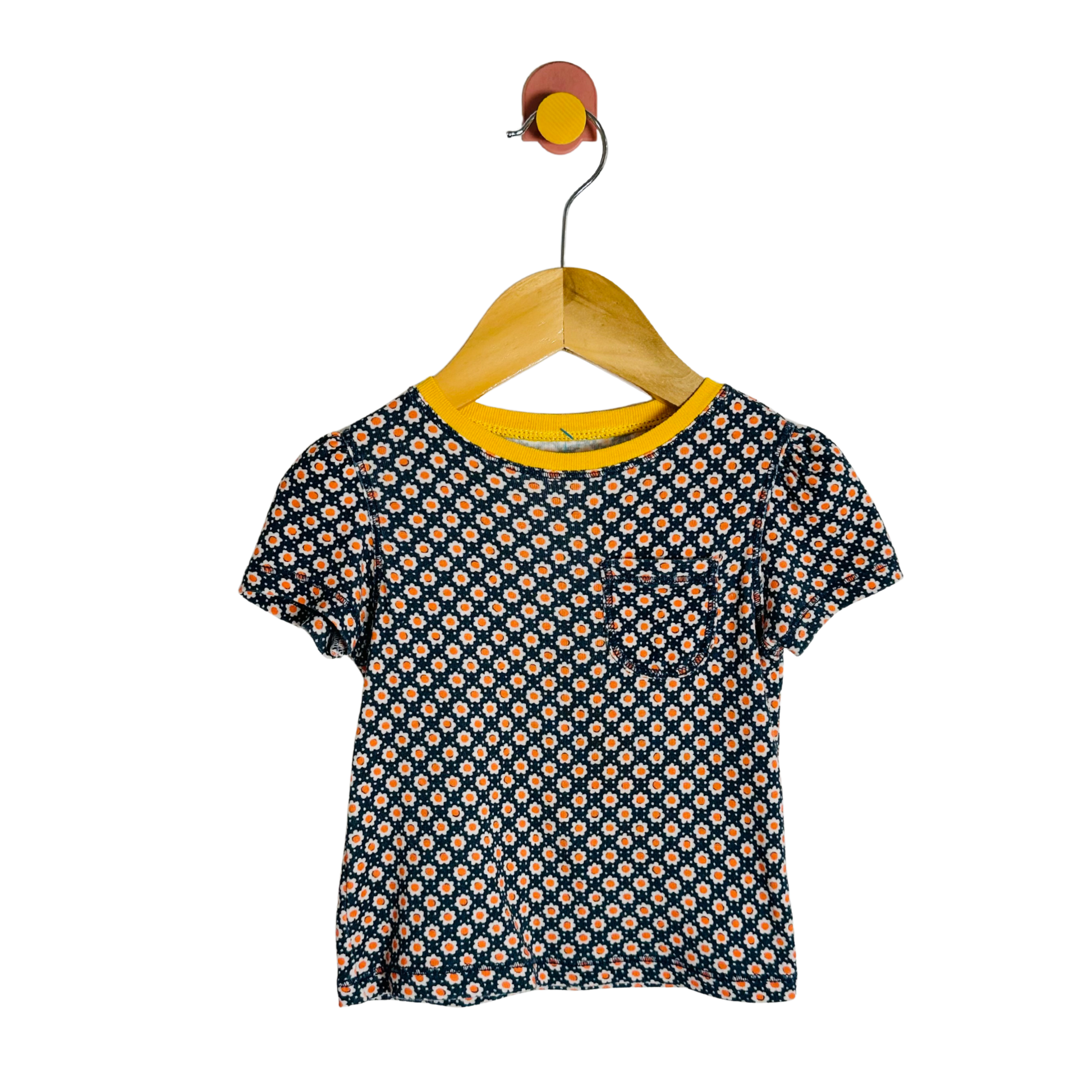 Children's floral shirt on a wooden hanger against a white background