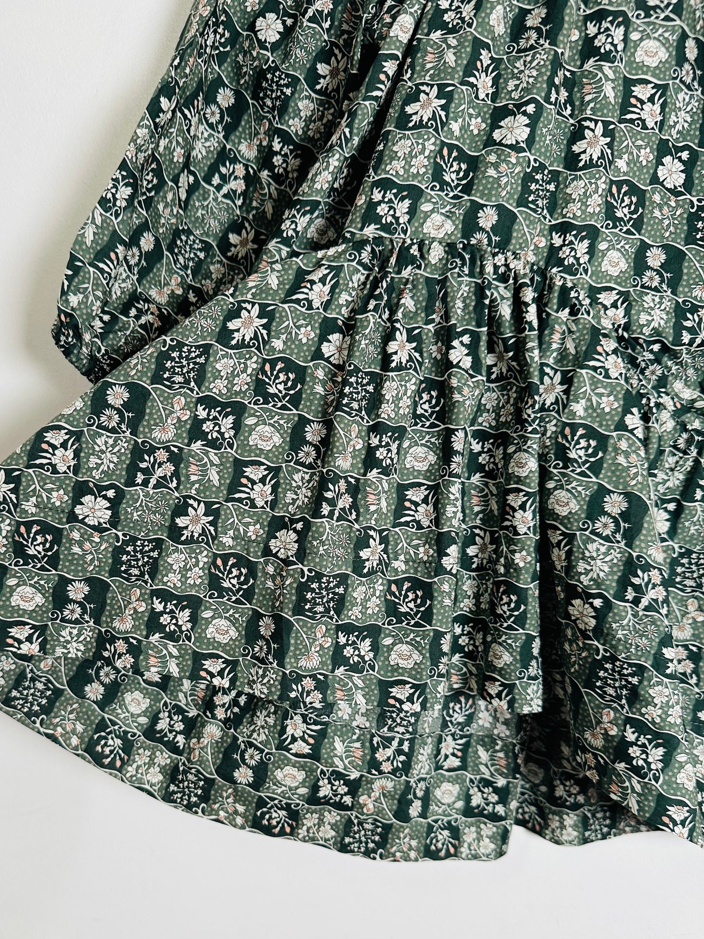 Green floral patterned fabric on a white background