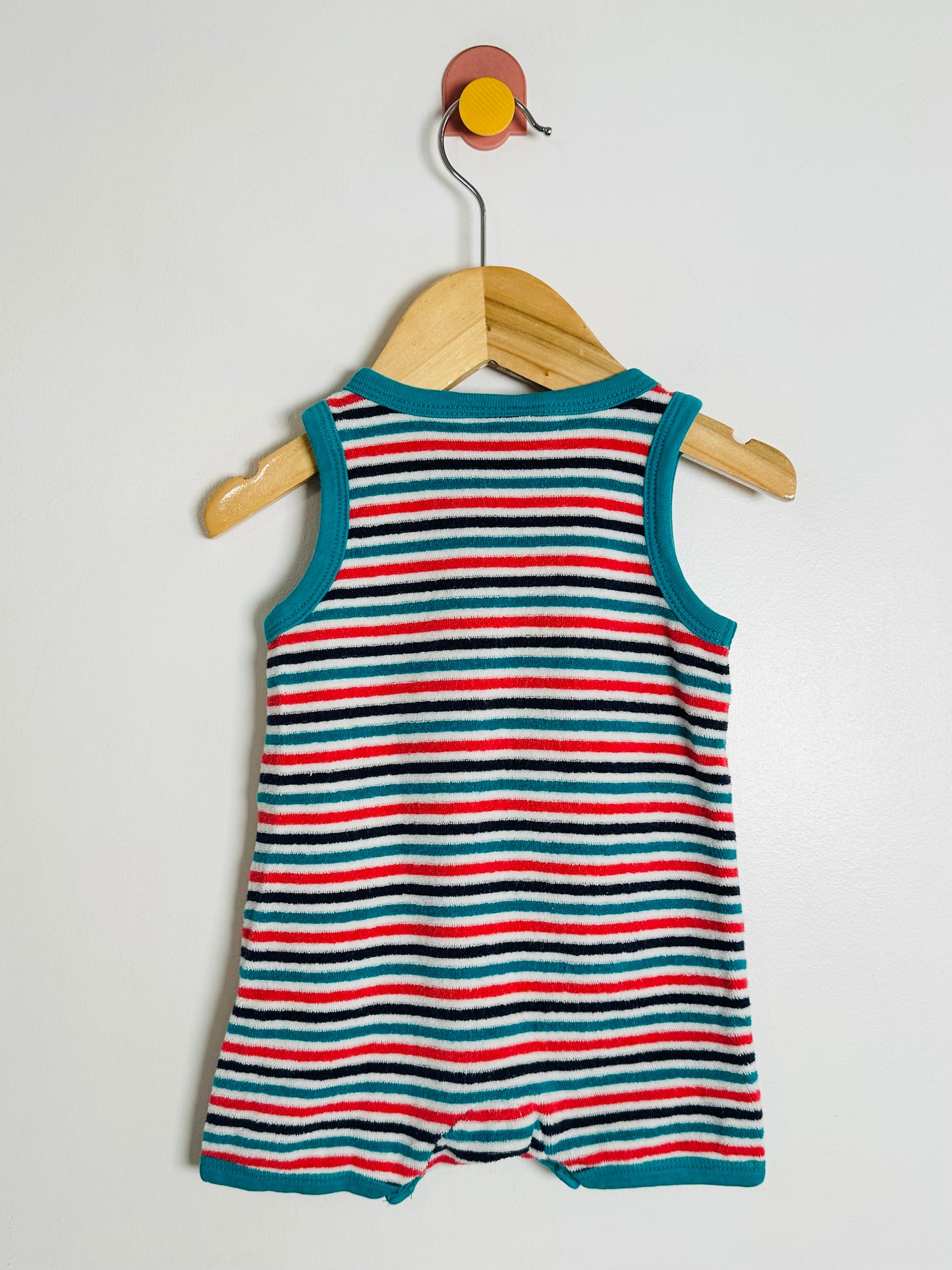 Striped baby romper on a hanger against a white background
