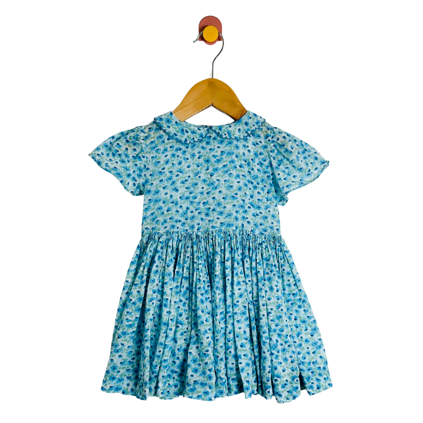 Blue floral dress on a wooden hanger against a white background