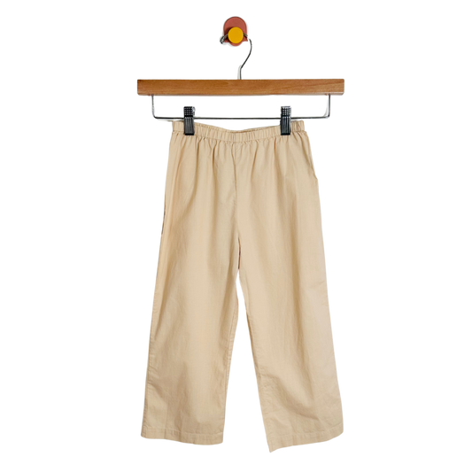 Beige pants on a hanger against a white background