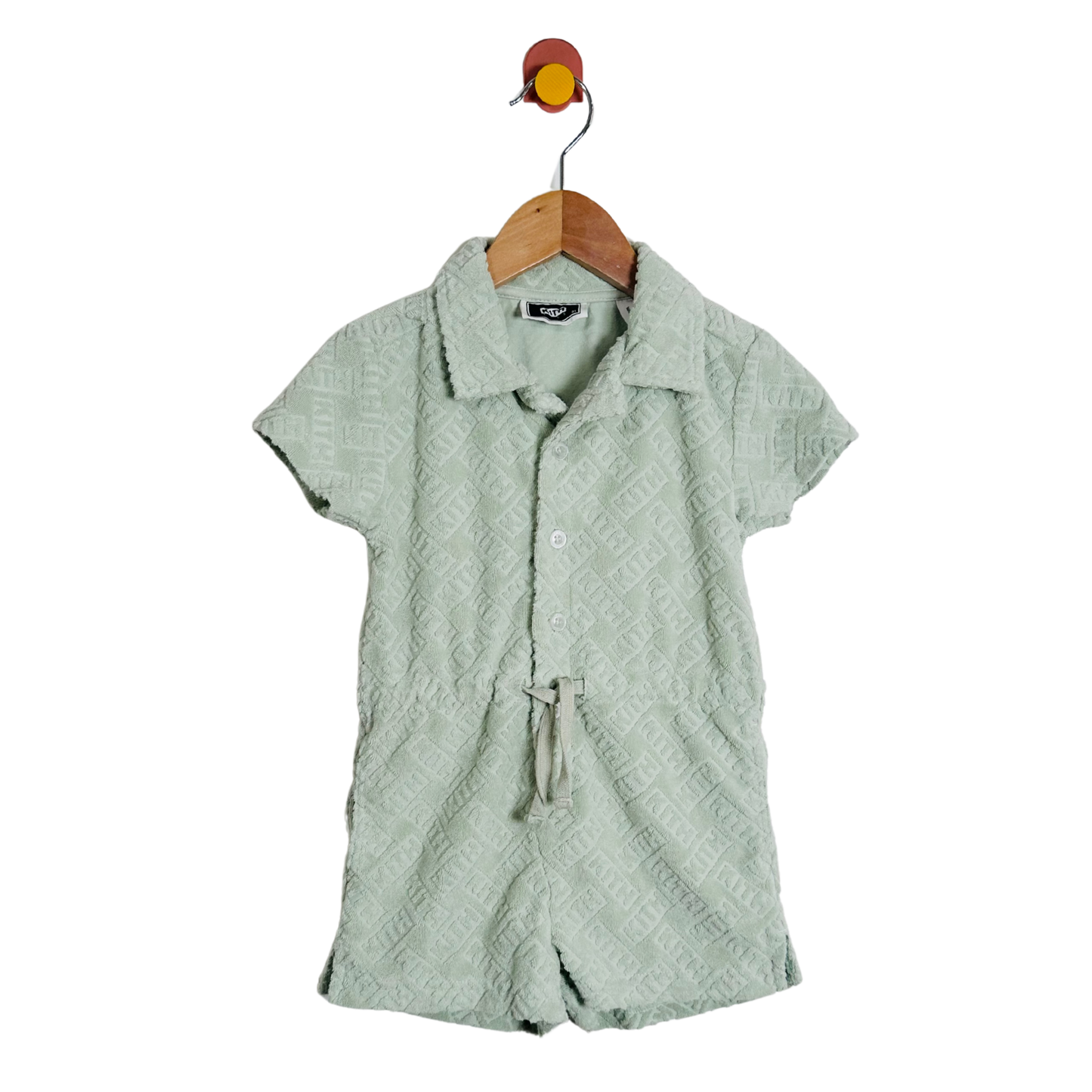 Green textured shirt on a hanger against a white background