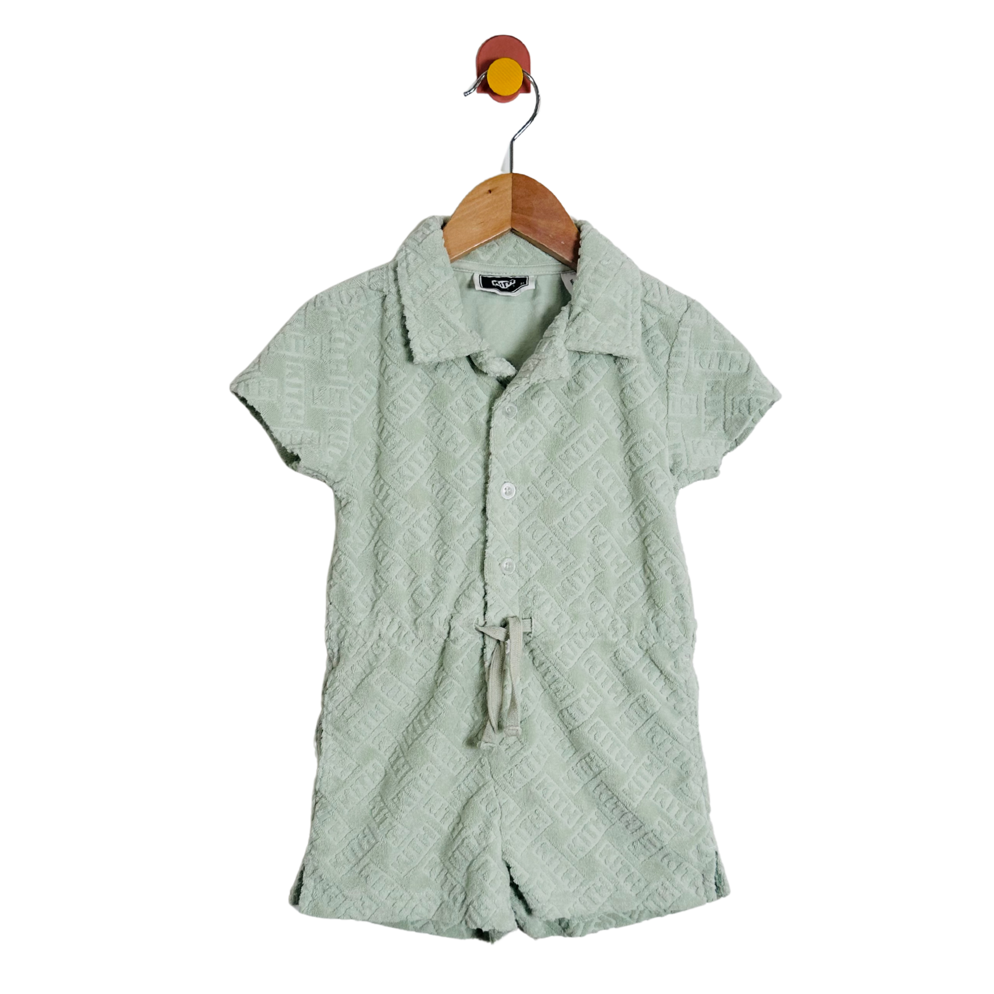 Green textured shirt on a hanger against a white background