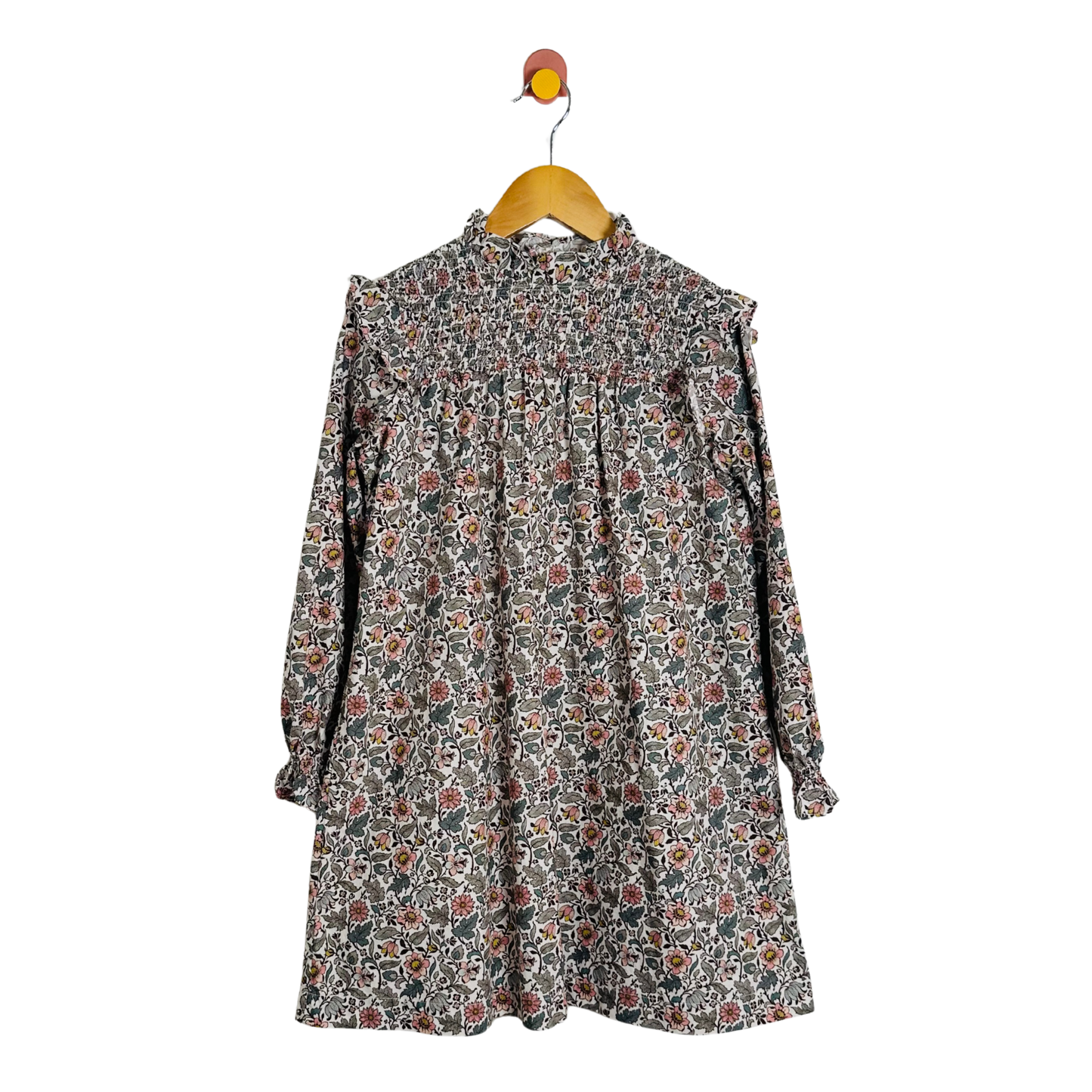 Floral dress on a hanger against a white background