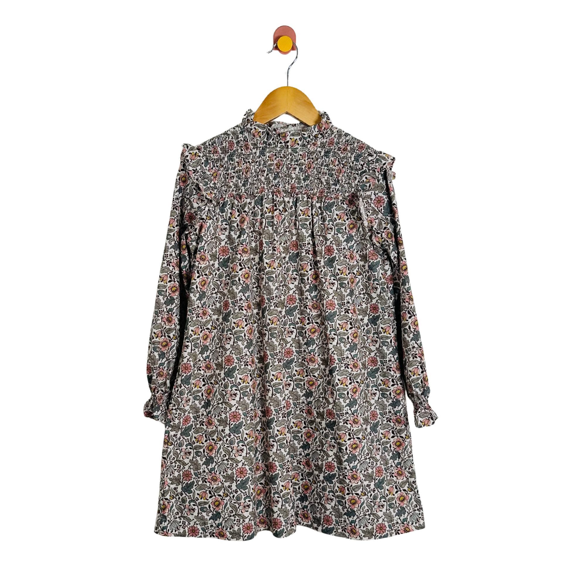 Floral dress on a hanger against a white background