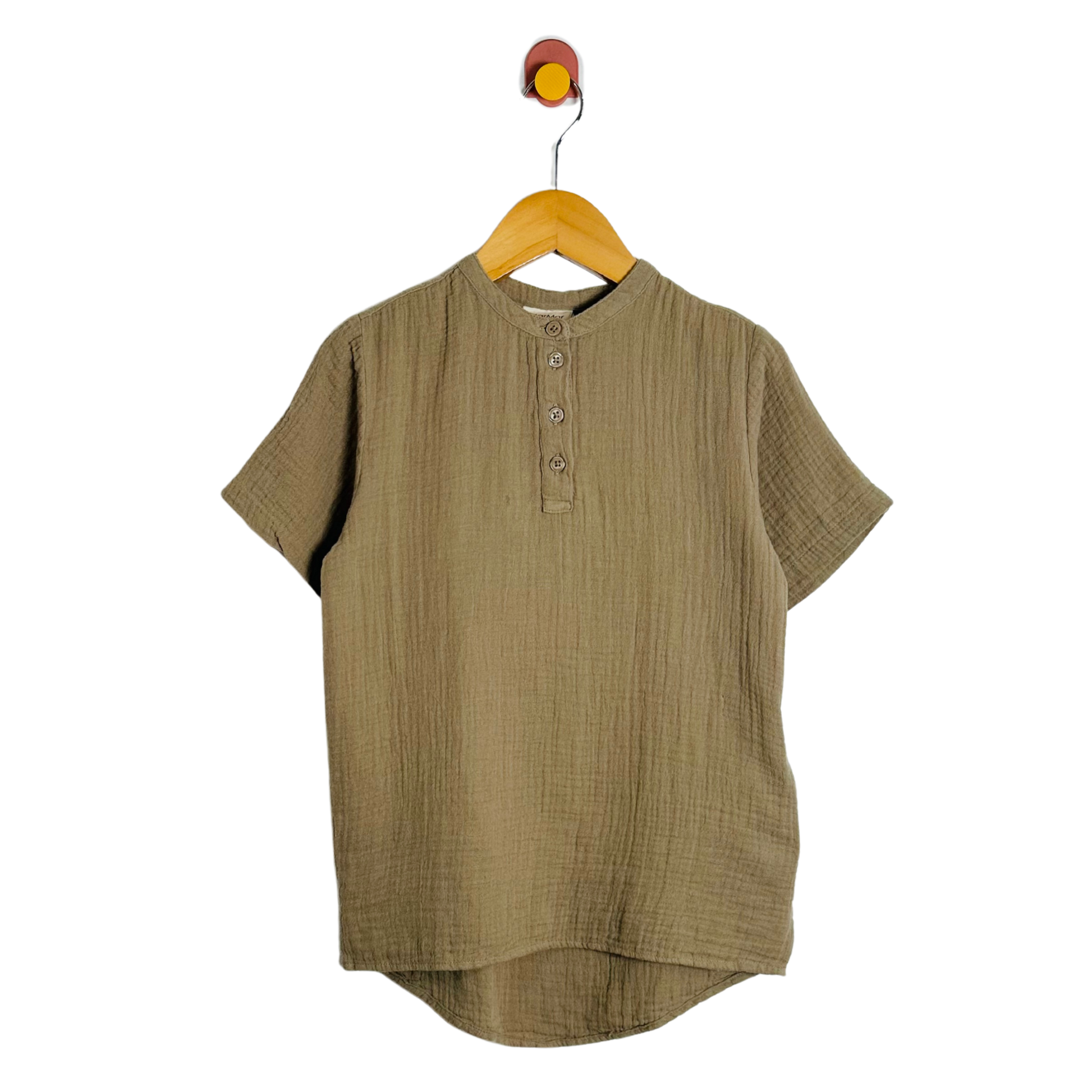 Green short-sleeve shirt on a wooden hanger against a white background
